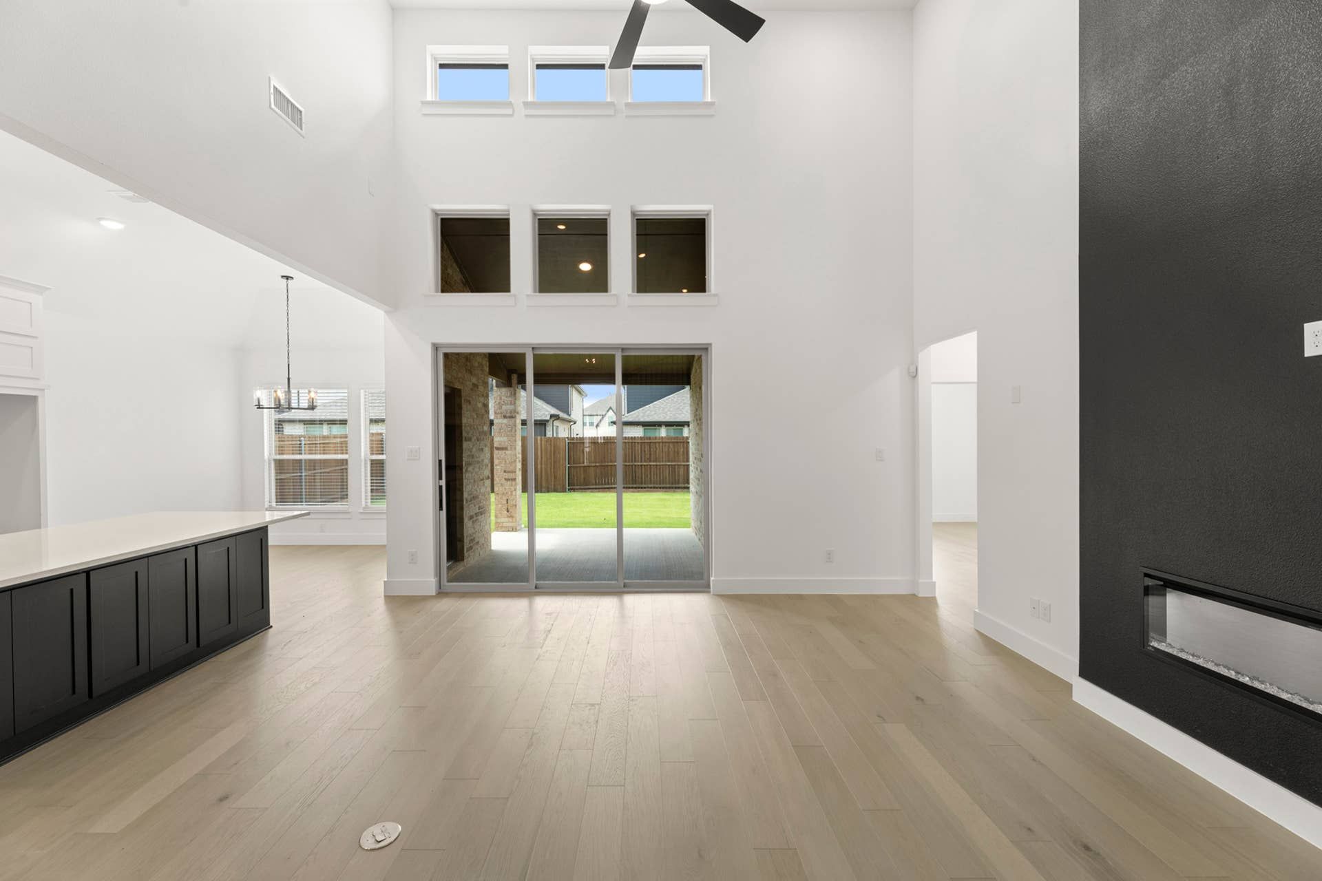 Spacious modern living area with high ceilings and large windows.