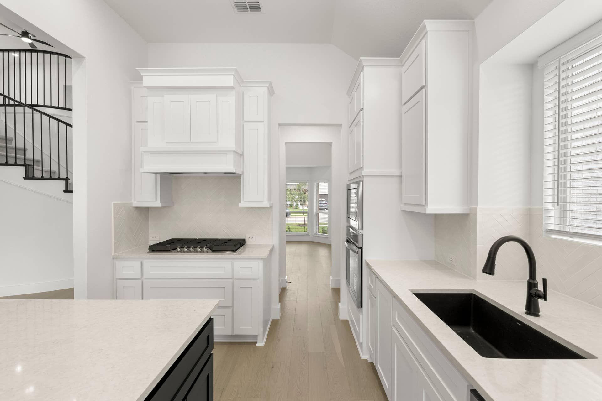 Modern kitchen with white cabinetry, black fixtures, and natural light.