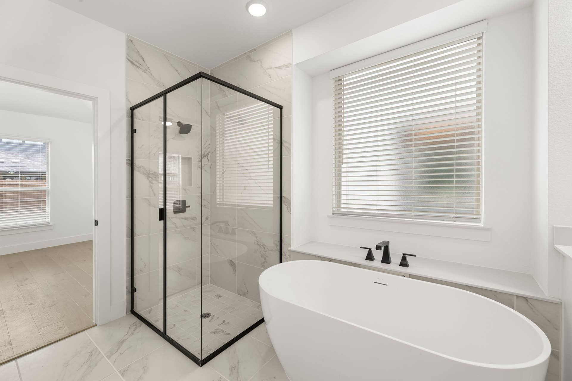 Modern bathroom with freestanding tub and glass-enclosed shower.