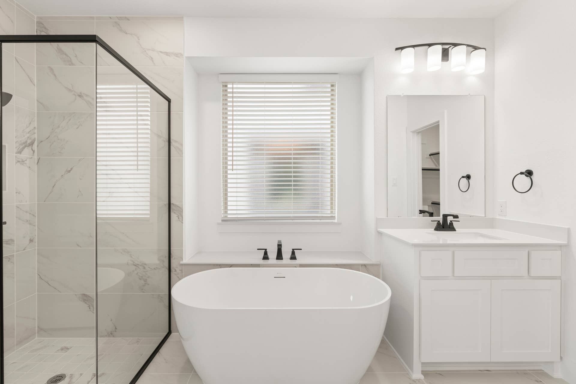 Modern bathroom with freestanding tub, glass shower, and white vanity.
