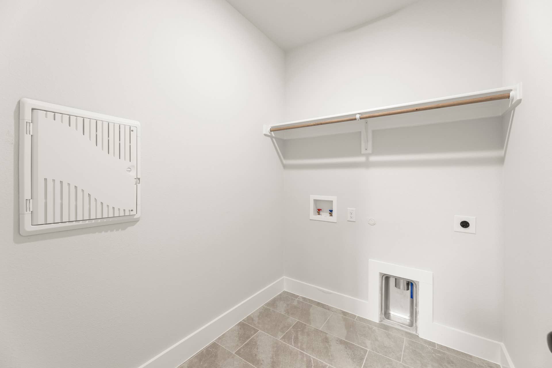 Utility room with tile flooring, wall connections, and overhead shelf.