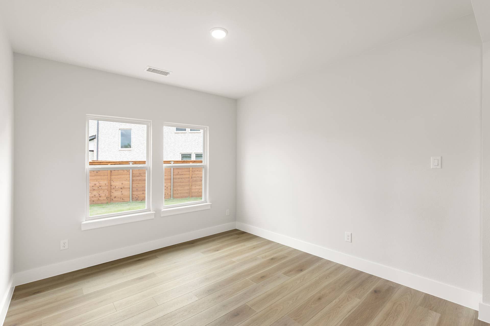 Bright dining room with hardwood floors and large windows.