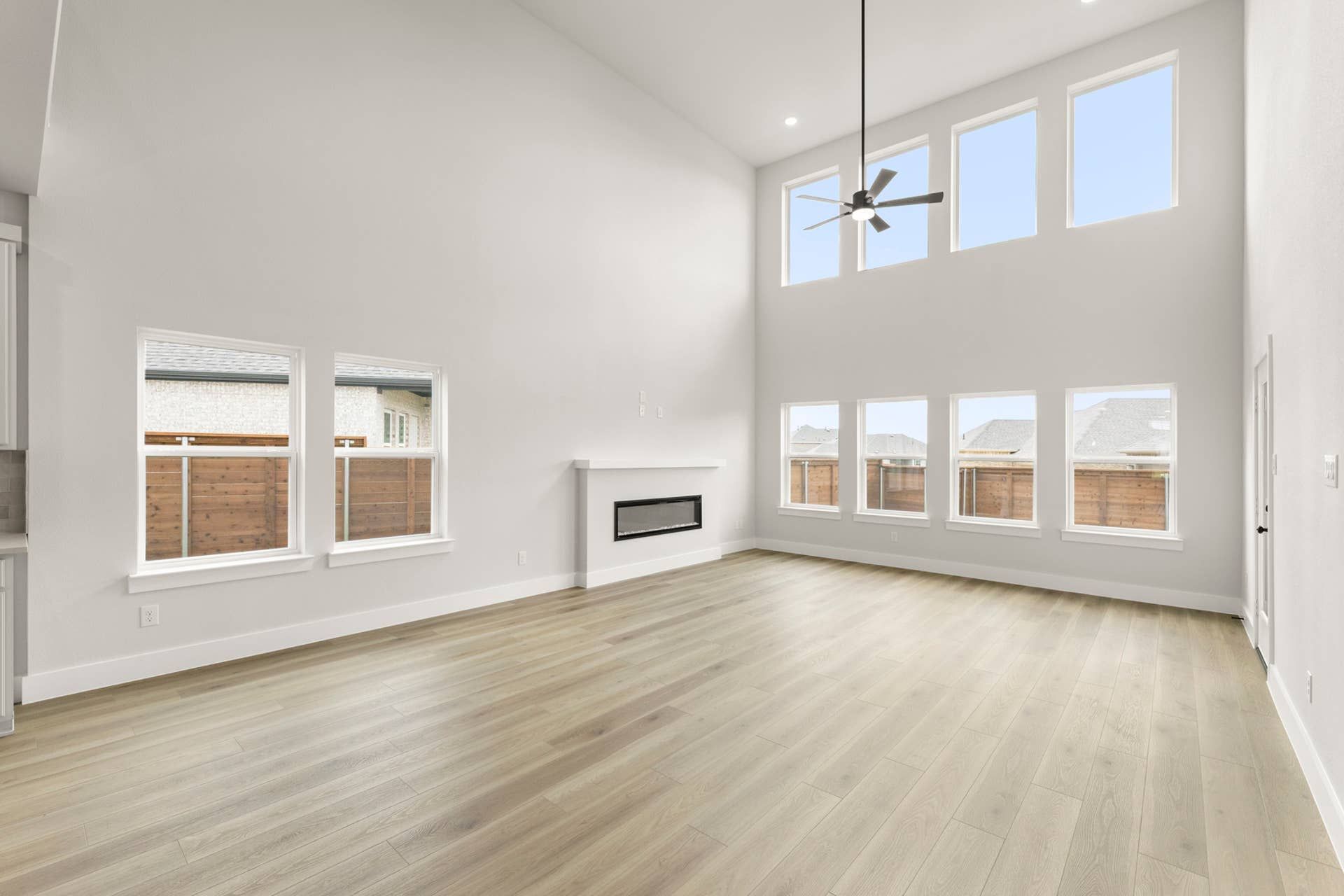 Spacious living area with high ceilings, large windows, and modern fireplace.