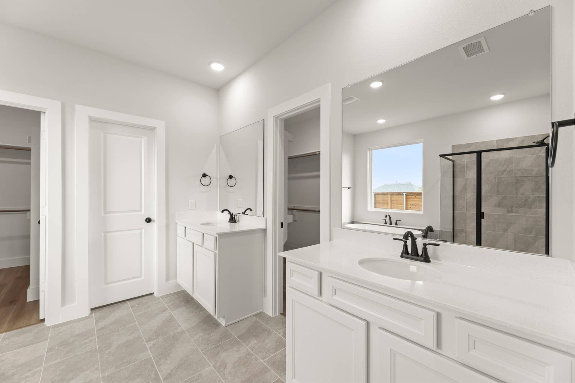 Spacious modern bathroom with dual vanities and large walk-in shower.