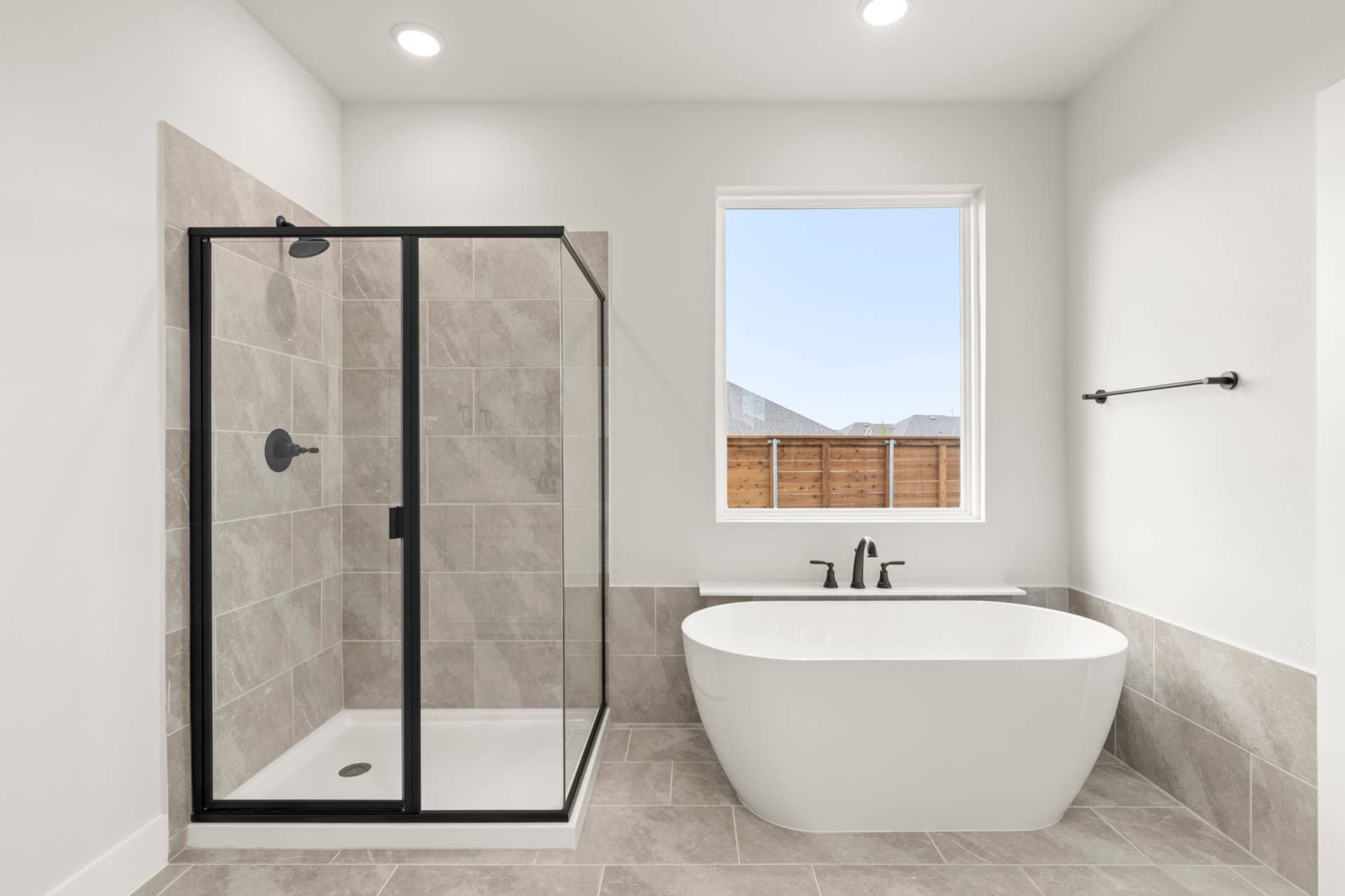 Modern bathroom with freestanding tub and glass-enclosed shower.