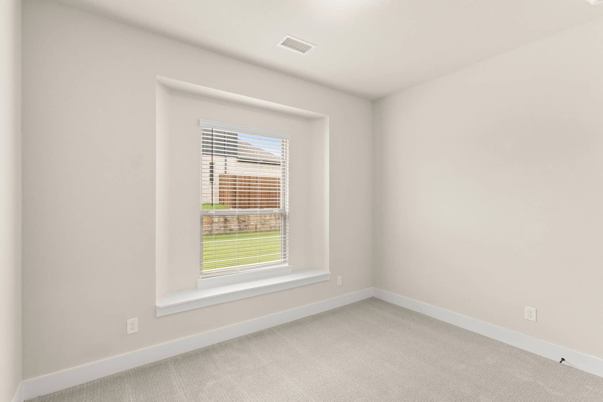 Bright study room with neutral walls and large window.