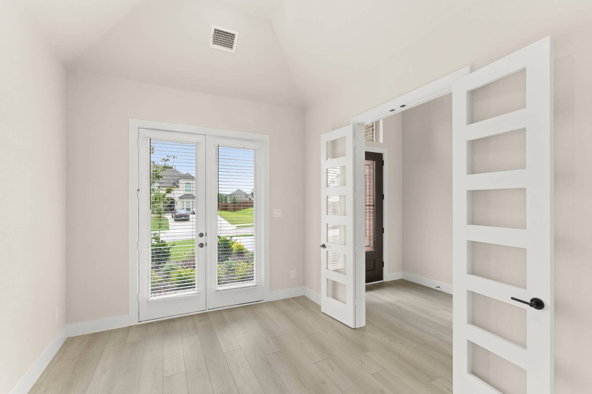 Bright dining room with glass doors and light wood flooring.