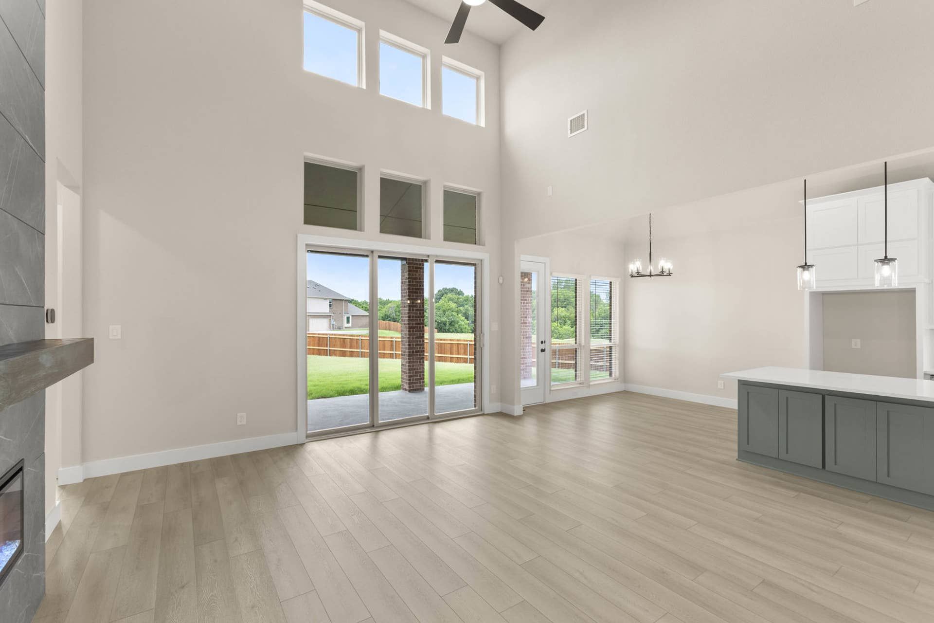 Spacious living room with high ceilings, modern fireplace, and large windows.