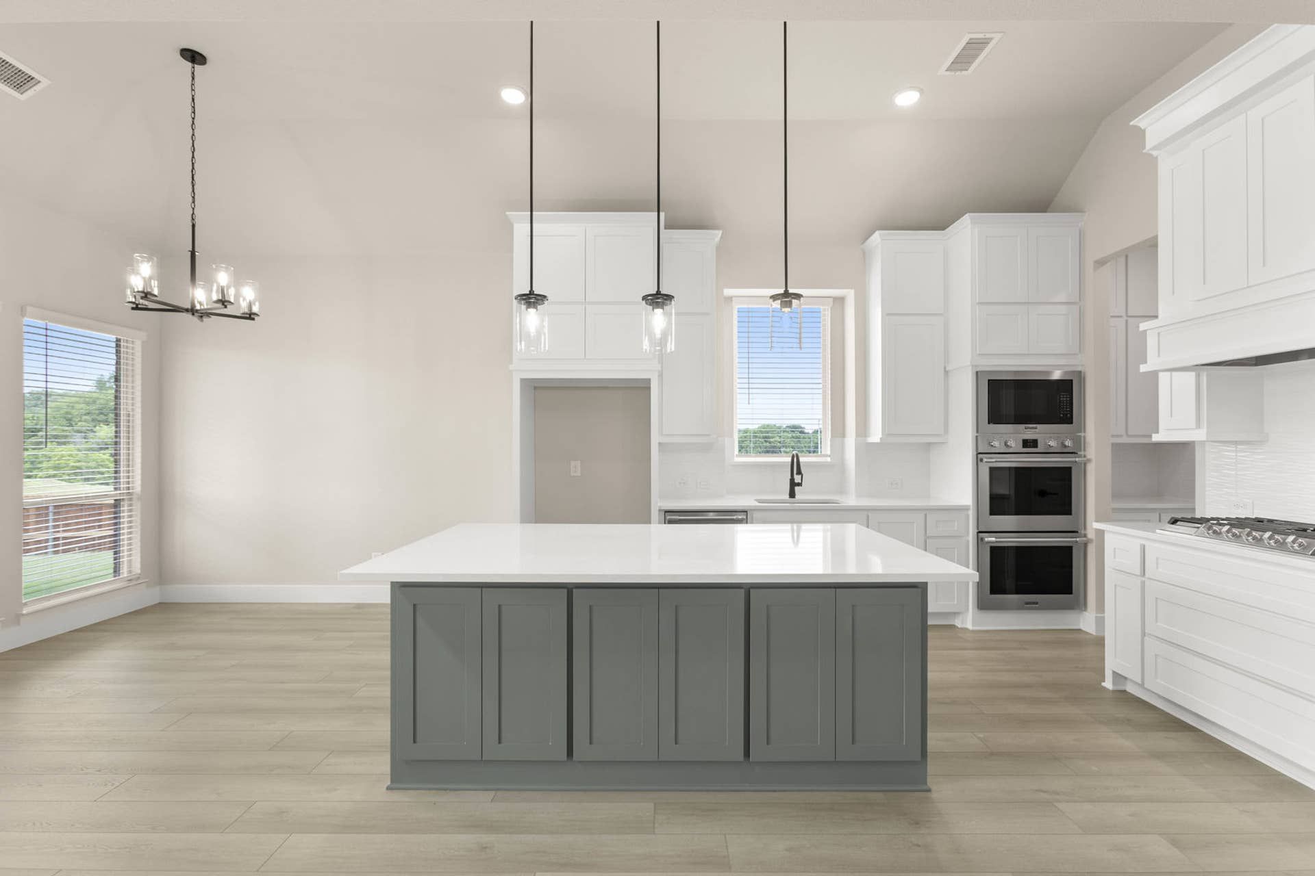 Modern kitchen with white cabinets, large island, and pendant lighting.