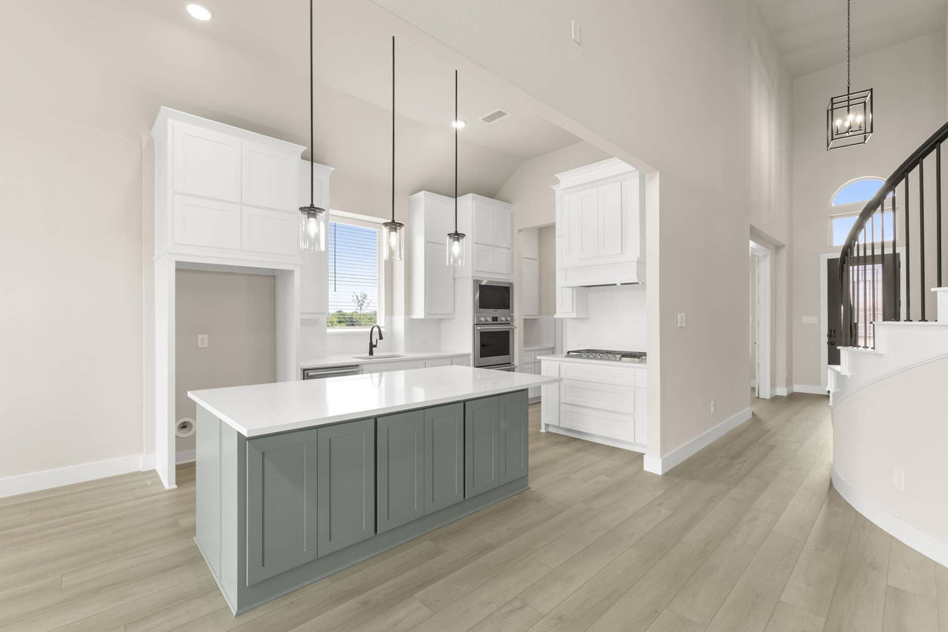 Modern kitchen with white cabinetry, island, and pendant lighting.