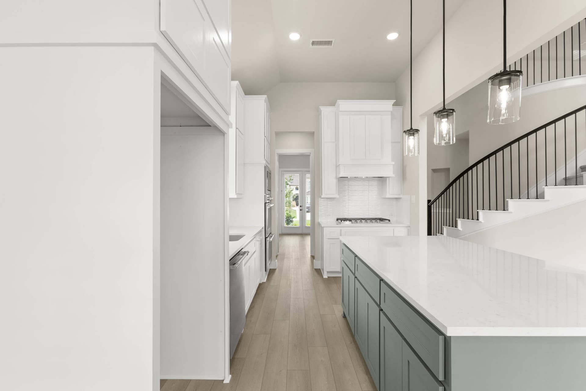 Modern kitchen with white cabinetry, island, and pendant lighting.
