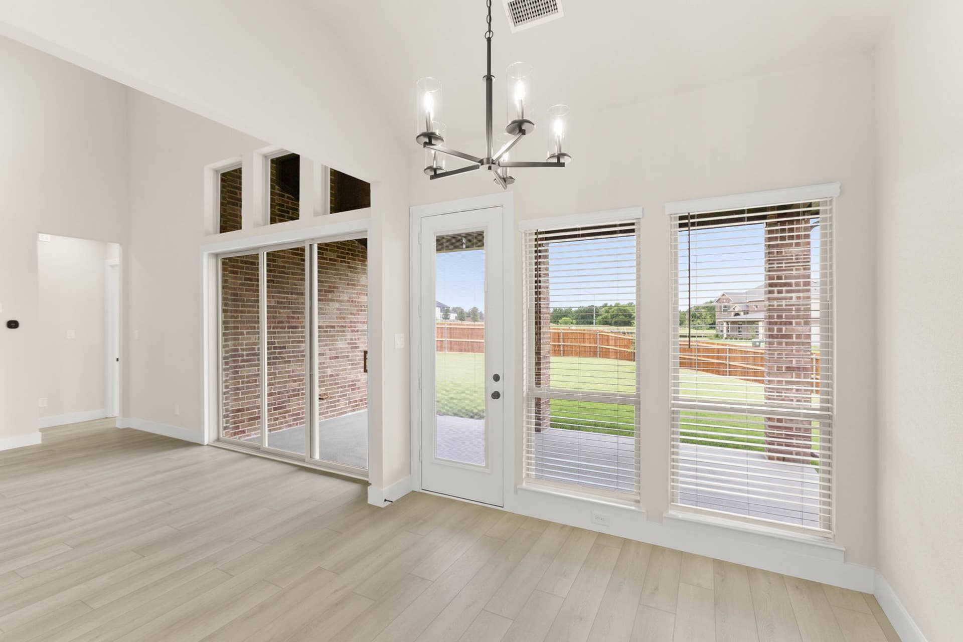 Modern breakfast nook with large windows and sliding door to backyard.