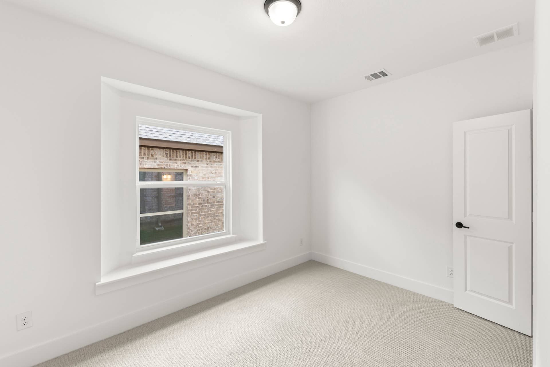 Representative photo of a bright, empty room with a large window and white walls.