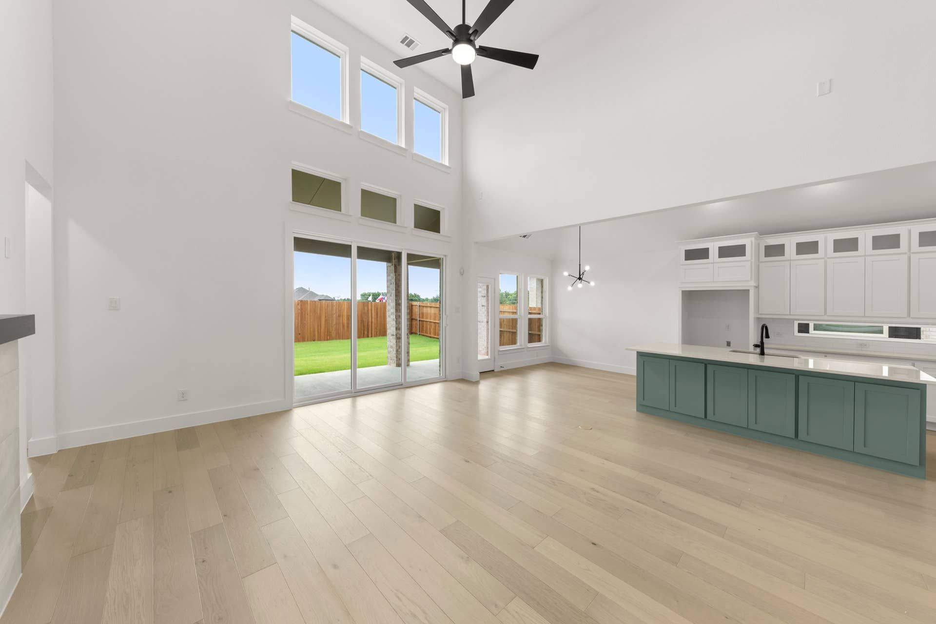 Spacious open-plan living area with high ceilings, large windows, and modern kitchen island.