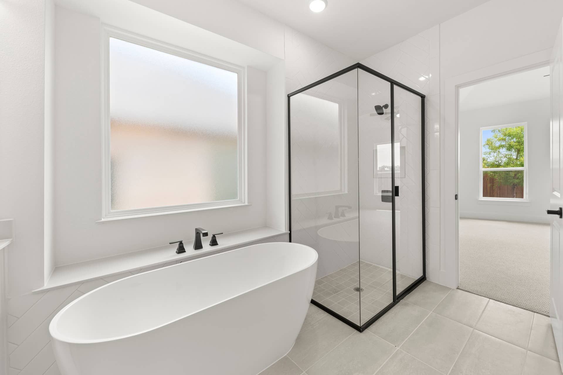 Modern bathroom with freestanding tub and glass-enclosed shower.