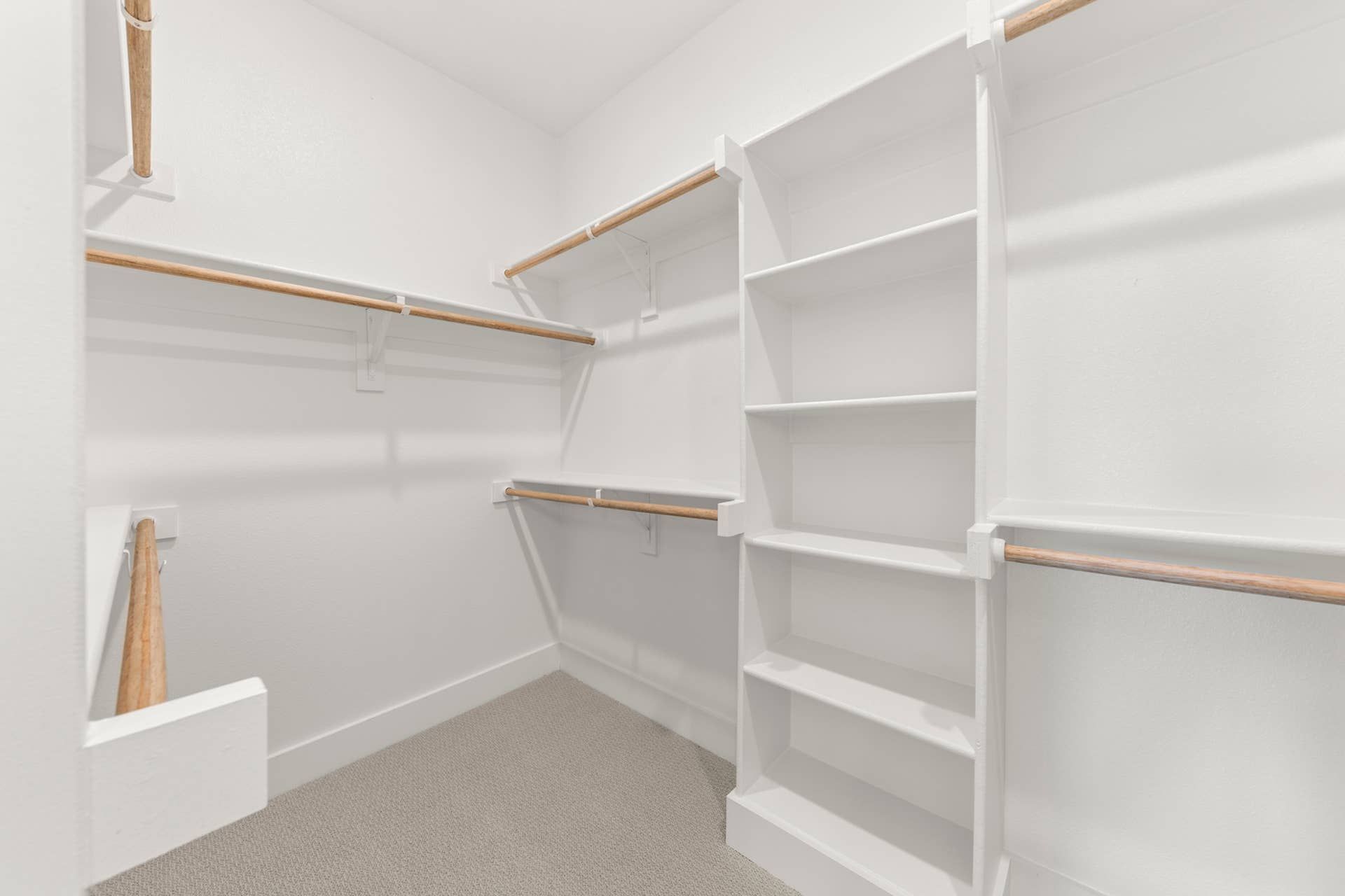 Spacious walk-in closet with built-in shelves and hanging rods.