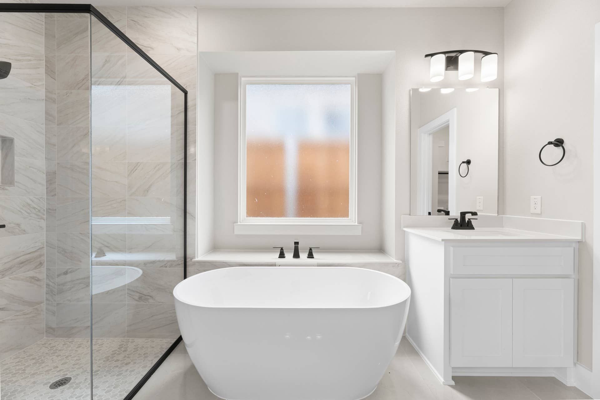 Modern bathroom with freestanding tub, glass shower, and sleek vanity.