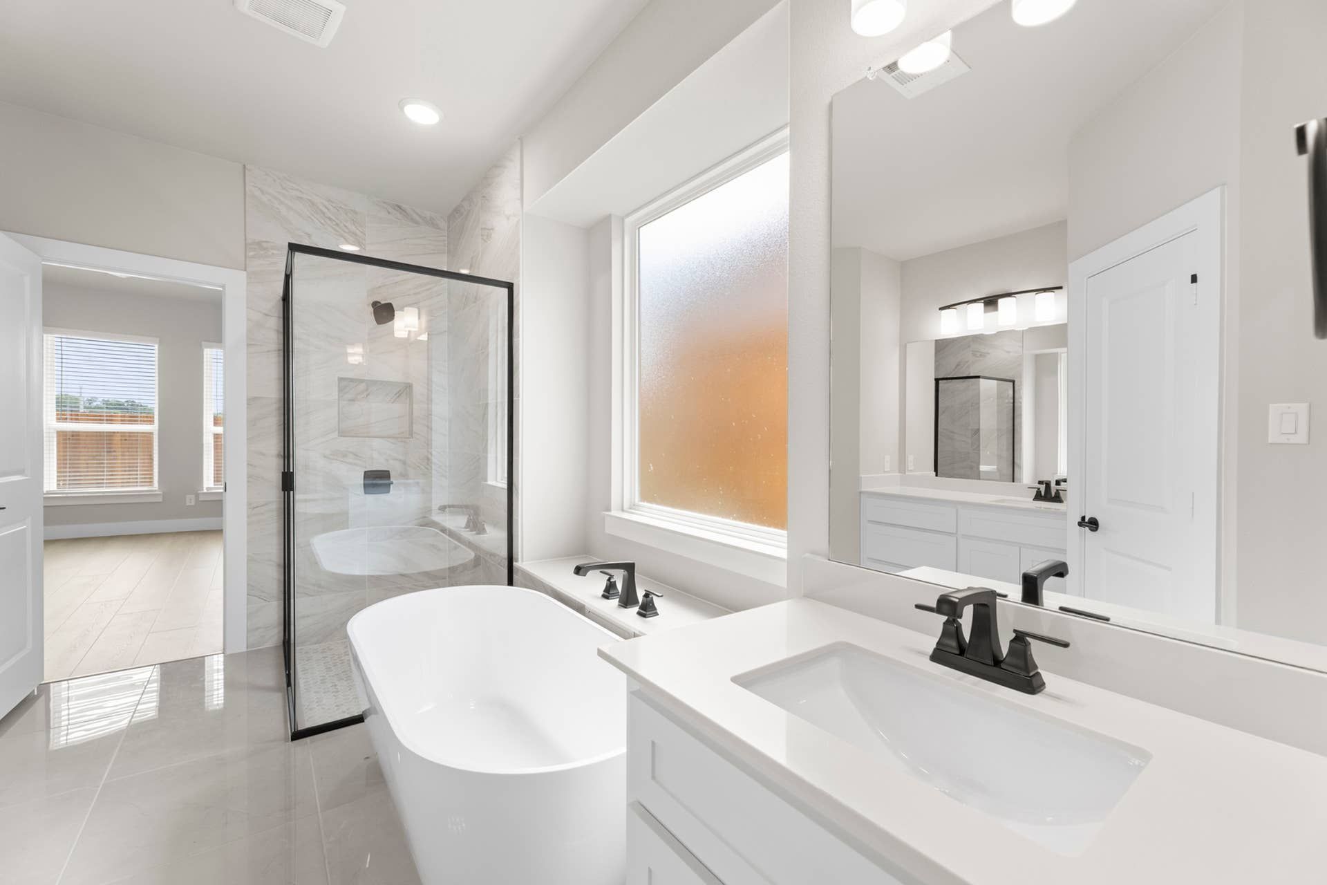 Luxurious bathroom with freestanding tub, glass shower, and modern fixtures.