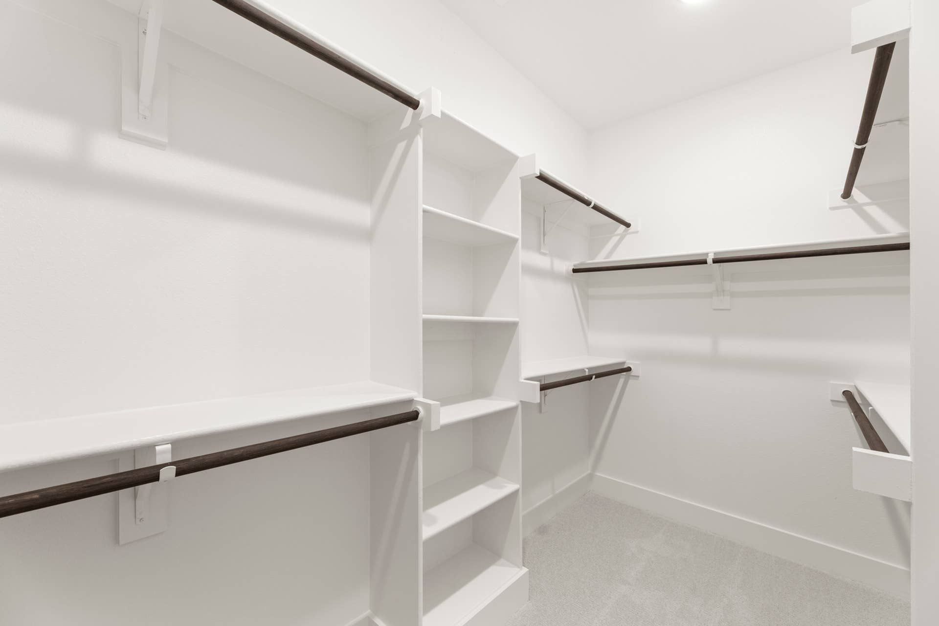 Spacious walk-in closet with multiple shelves and hanging rods.