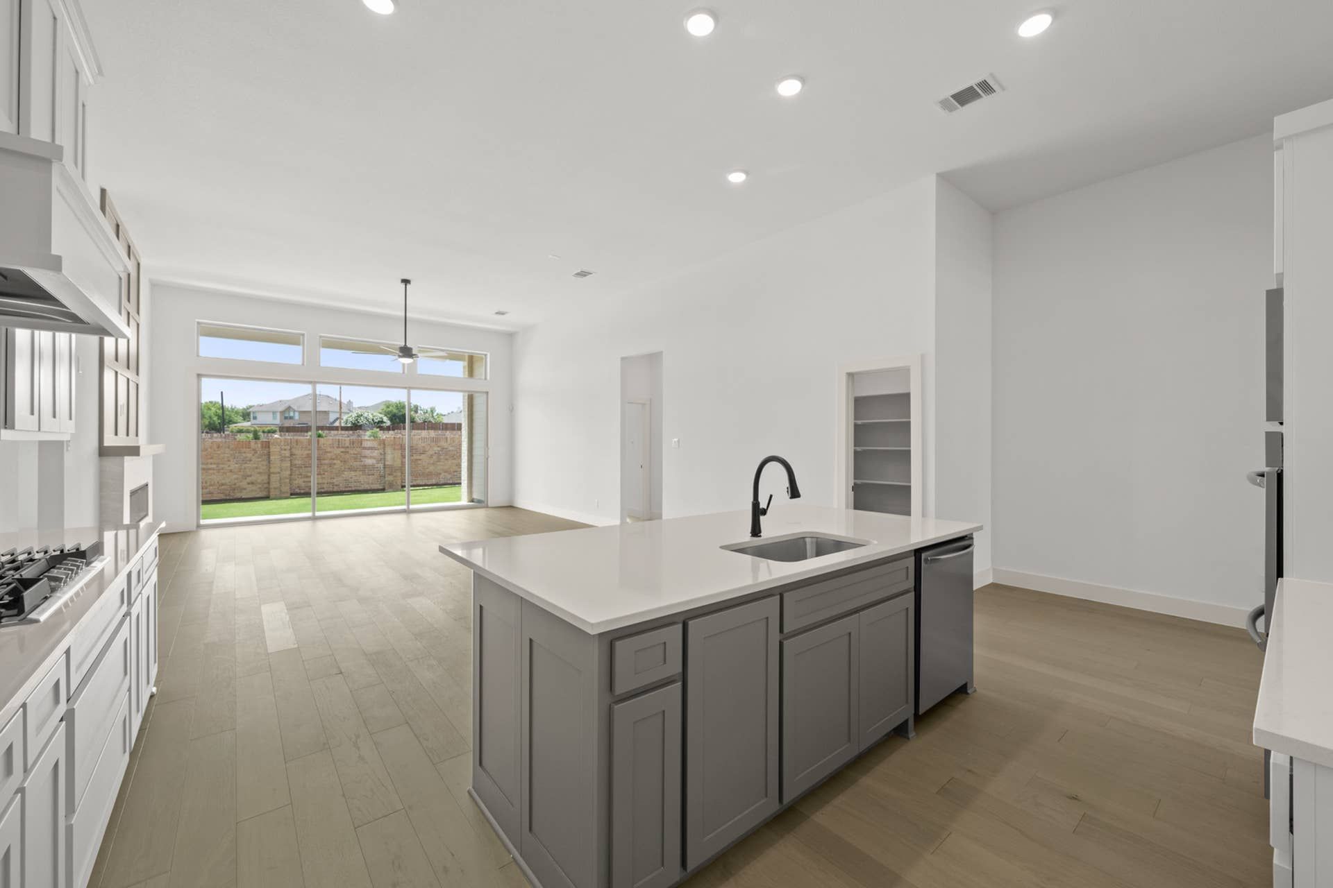 Spacious kitchen with island, large windows, and wood flooring.