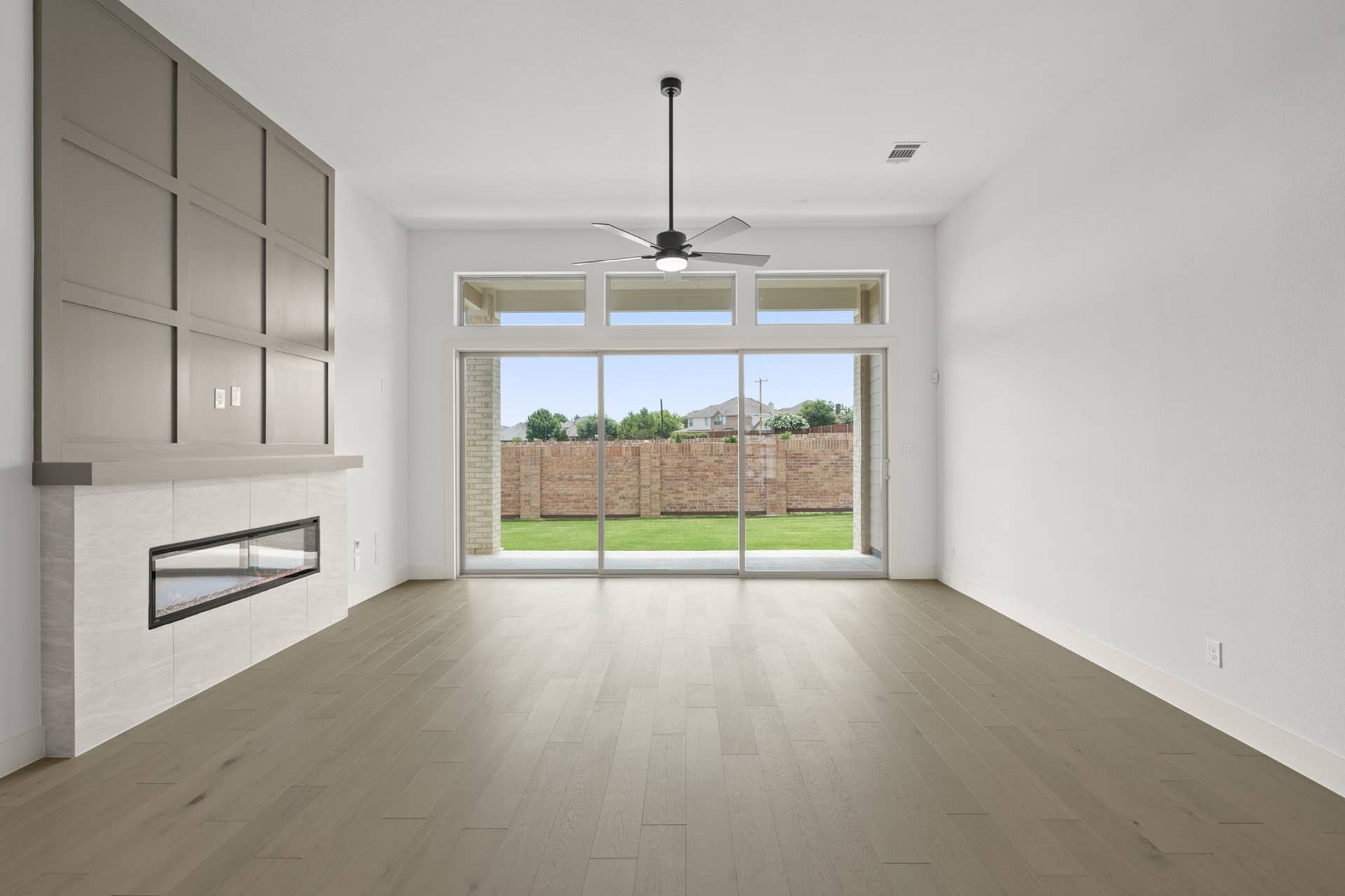 Spacious living room with modern fireplace and large sliding glass doors.