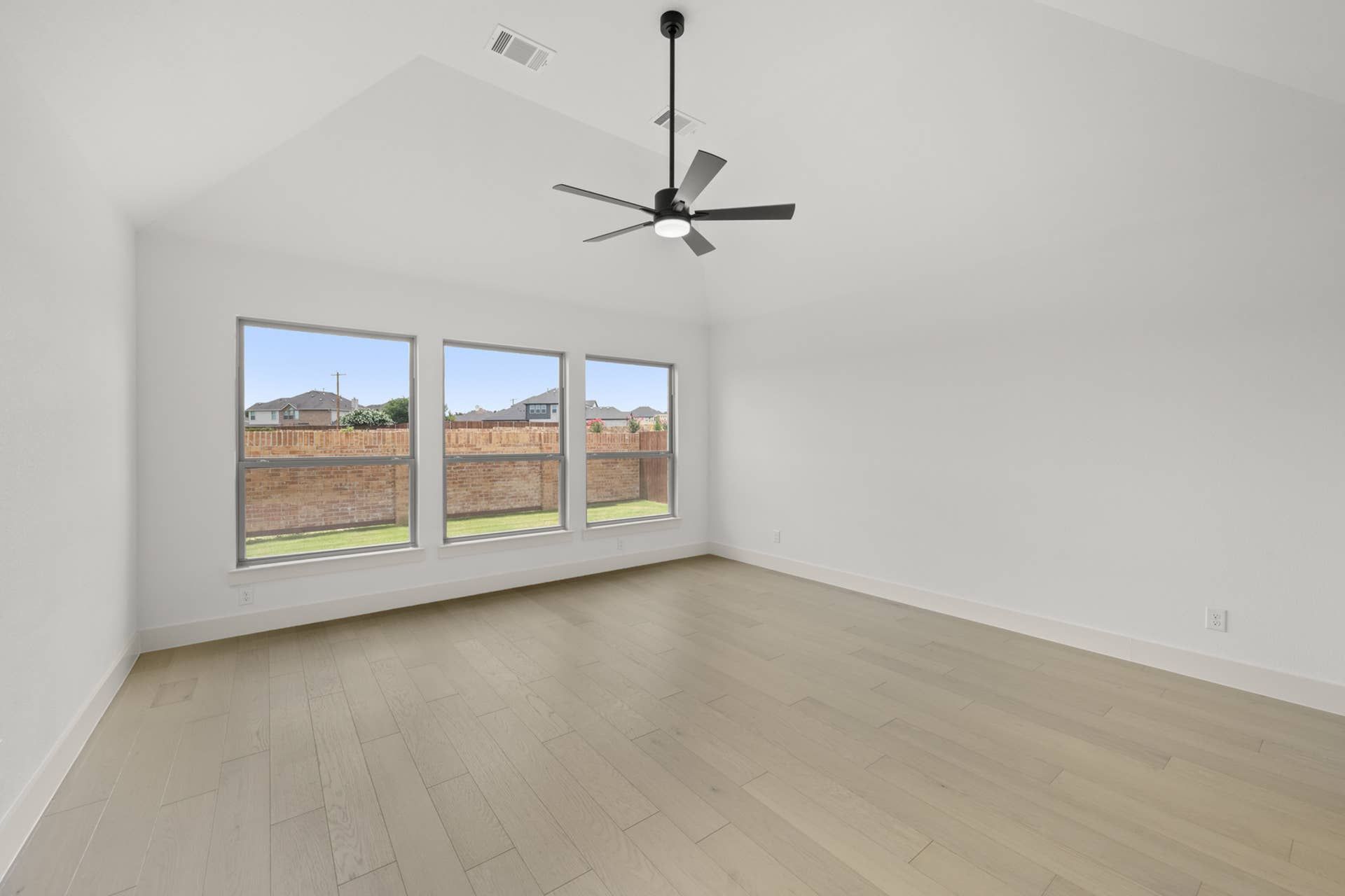 Spacious primary suite with vaulted ceiling and large windows.