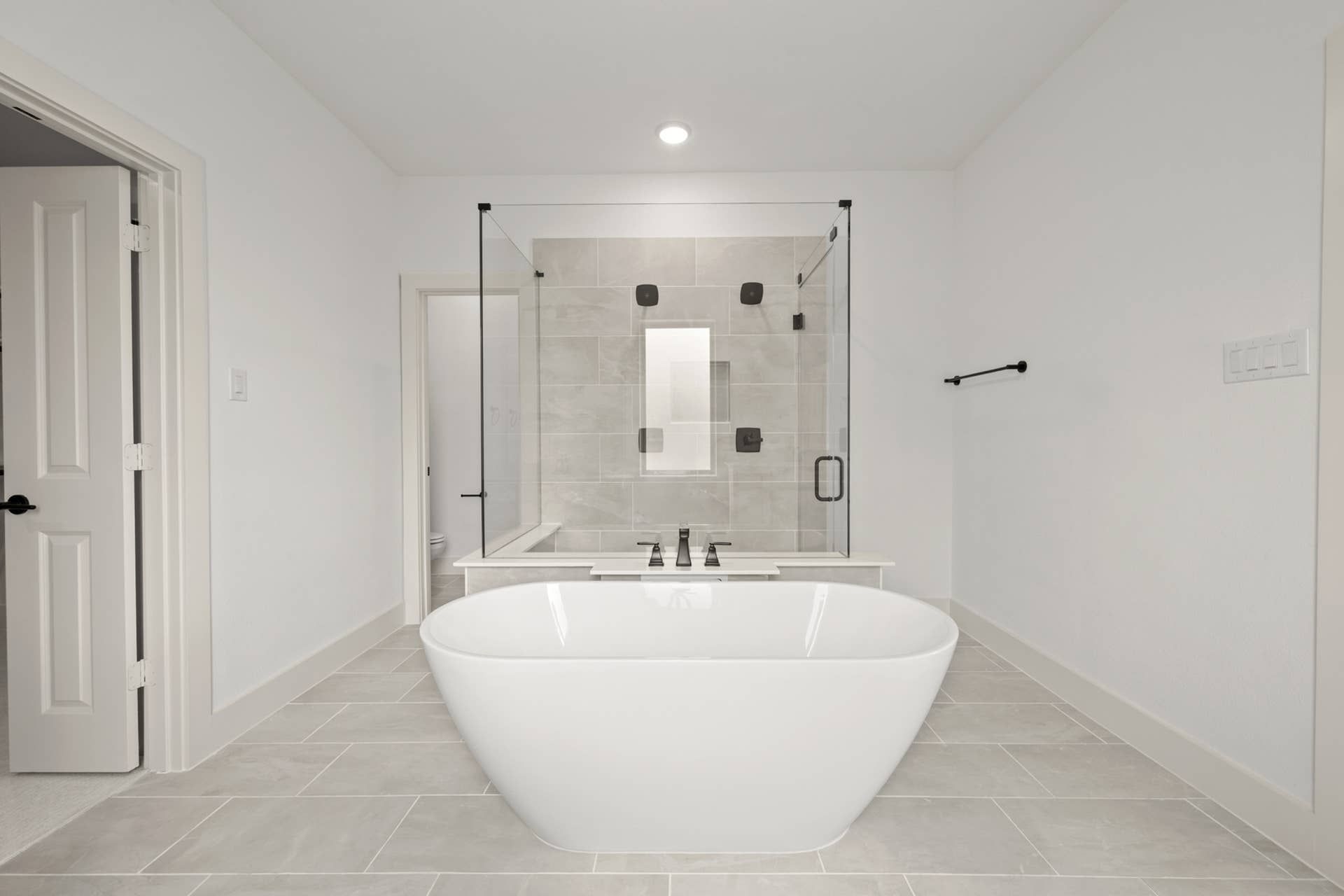 Luxurious bathroom with freestanding tub and glass-enclosed shower.