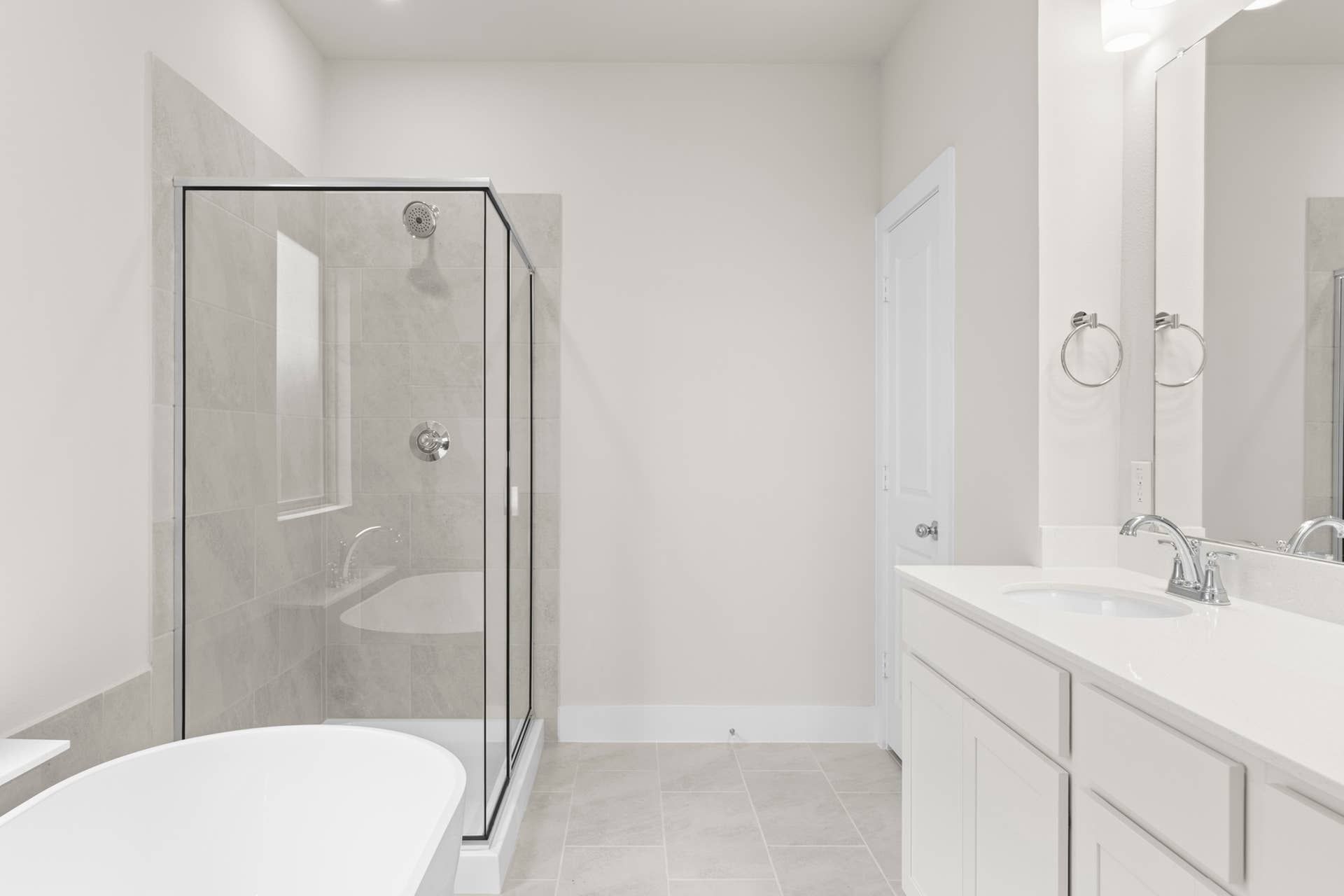 Modern bathroom with glass shower, freestanding tub, and dual-sink vanity.