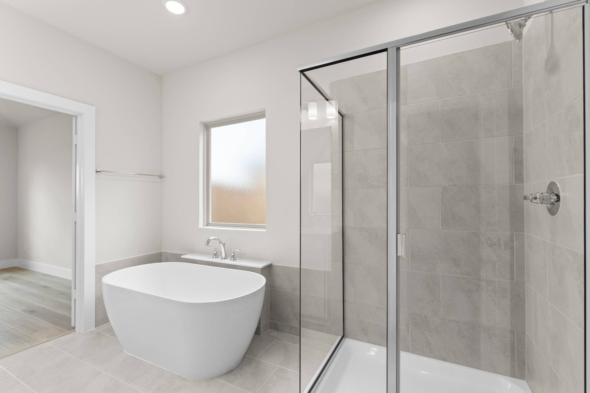 Modern bathroom with freestanding tub and glass-enclosed shower.