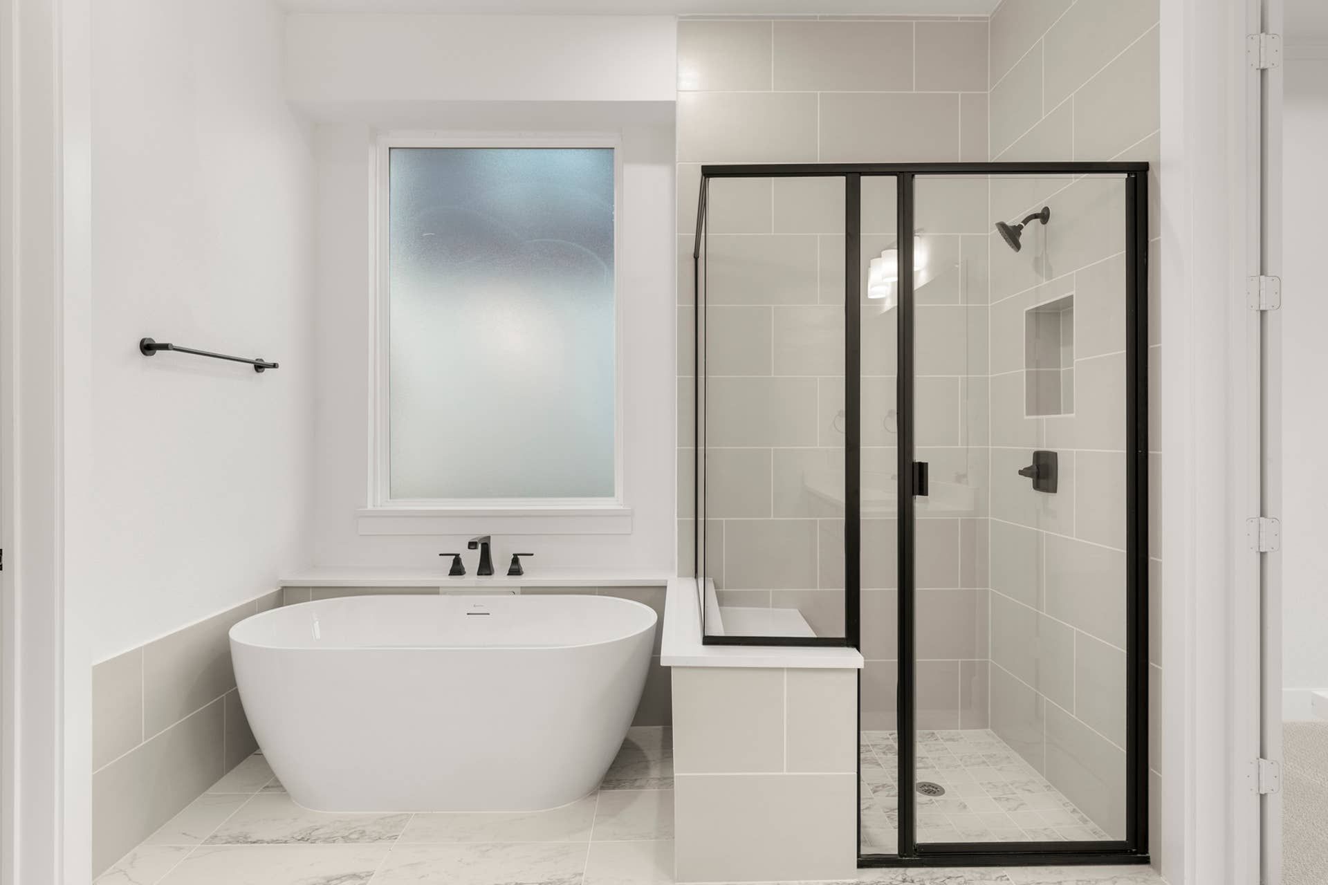 Modern bathroom with freestanding tub and glass-enclosed shower.