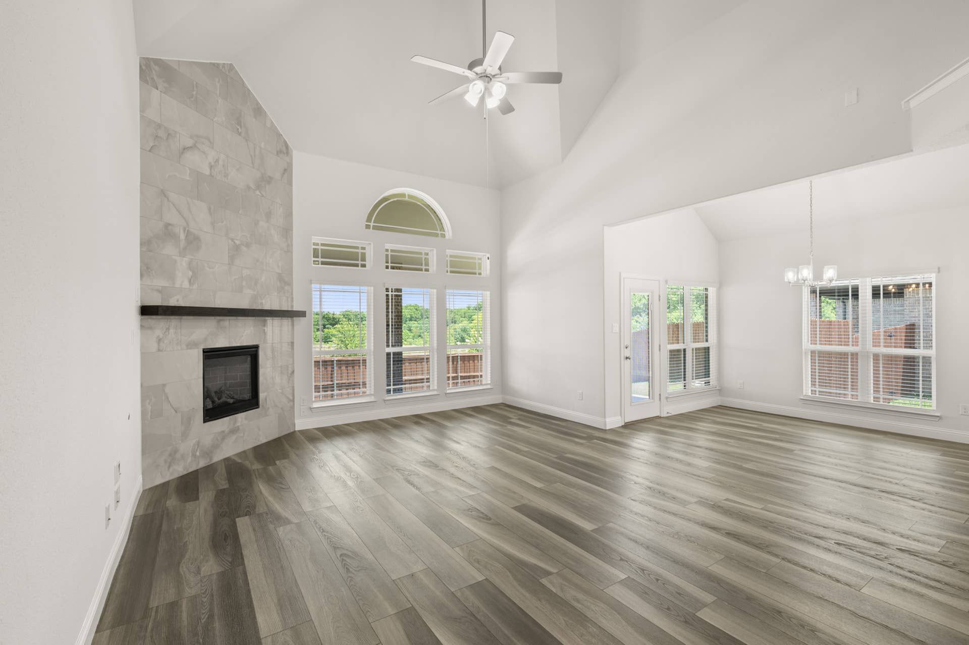 Spacious living room with high ceilings, fireplace, and large windows.