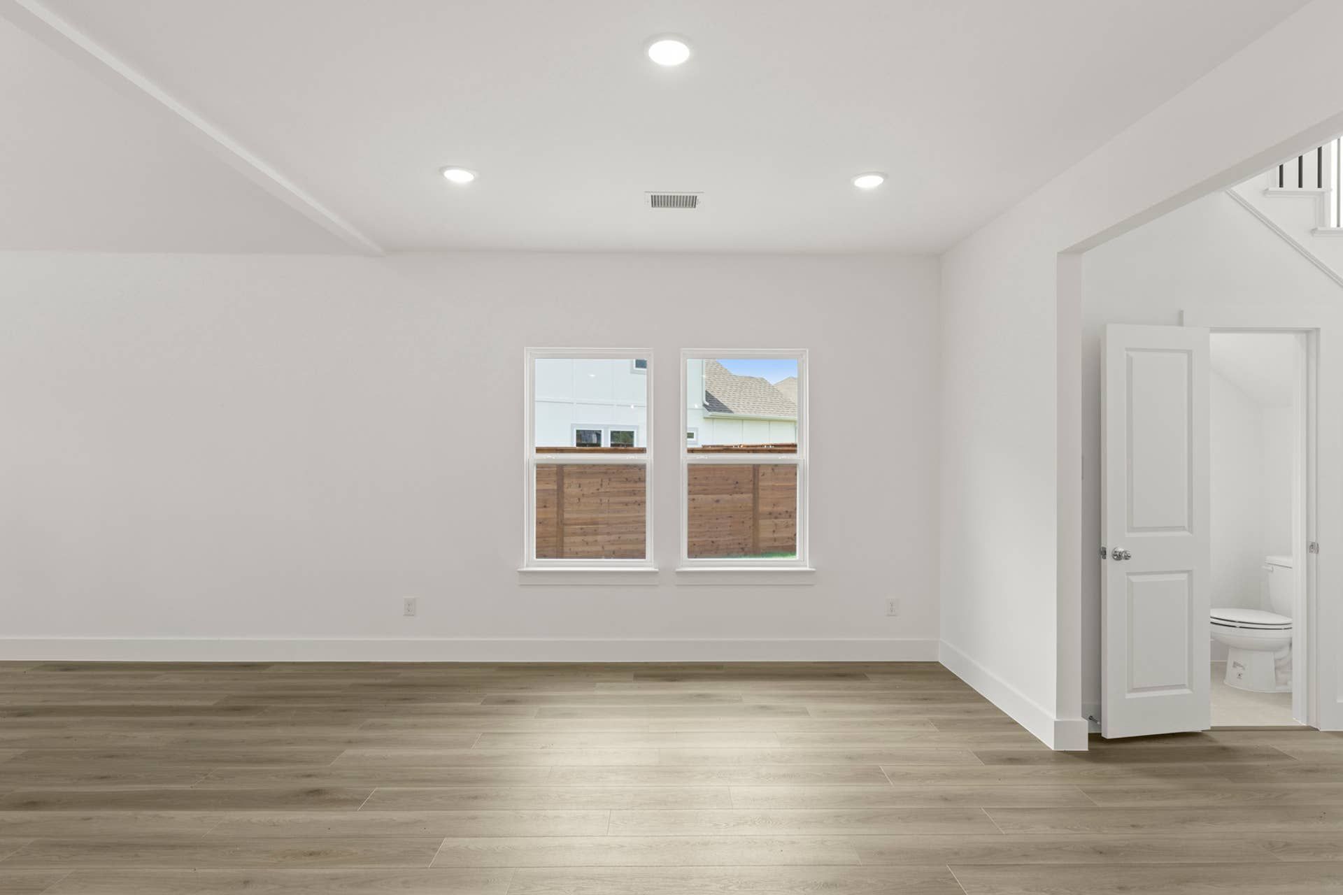 Spacious dining area with wood flooring and recessed lighting.