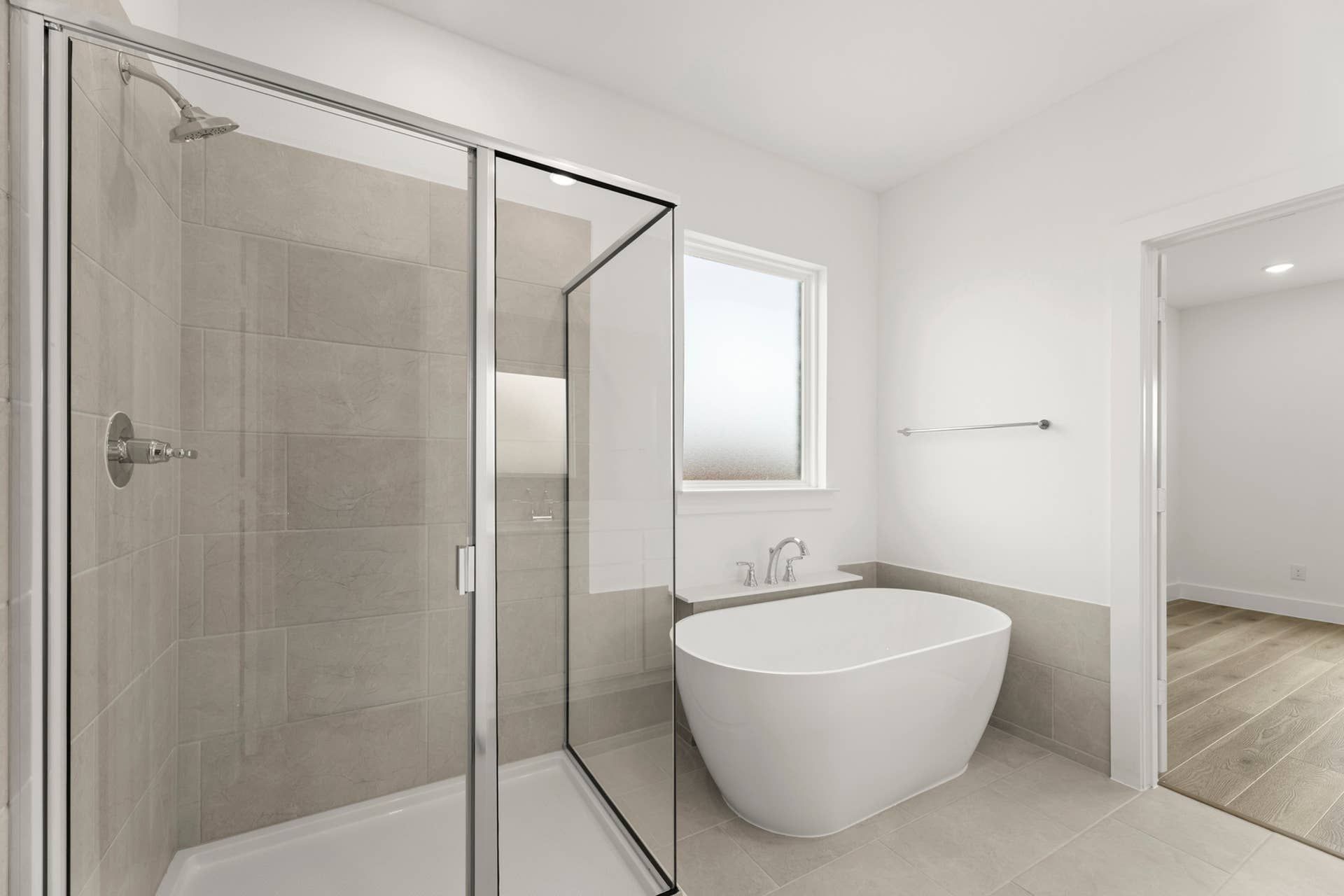Modern bathroom with glass shower and freestanding bathtub.