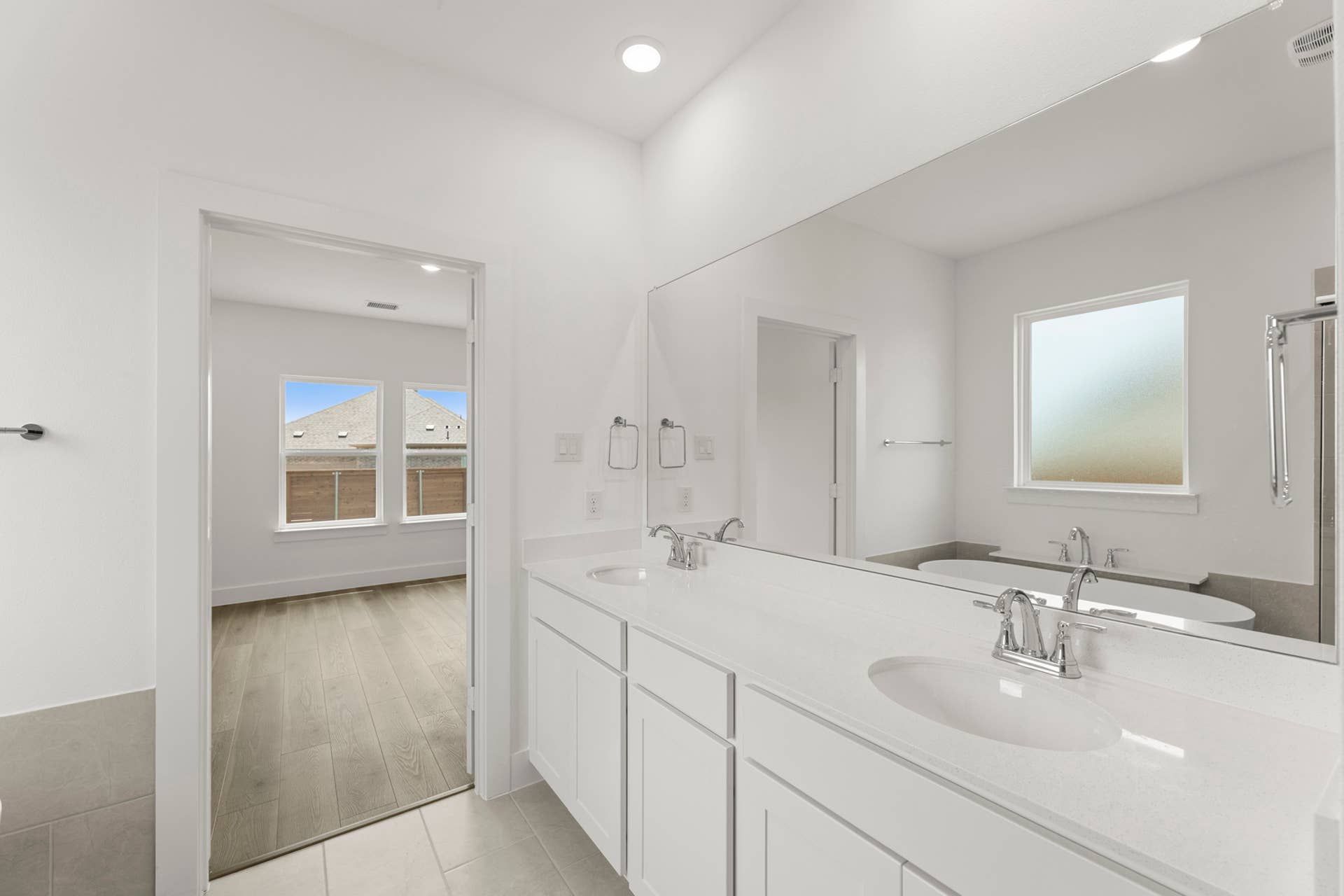 Modern bathroom with double vanity and large mirror.
