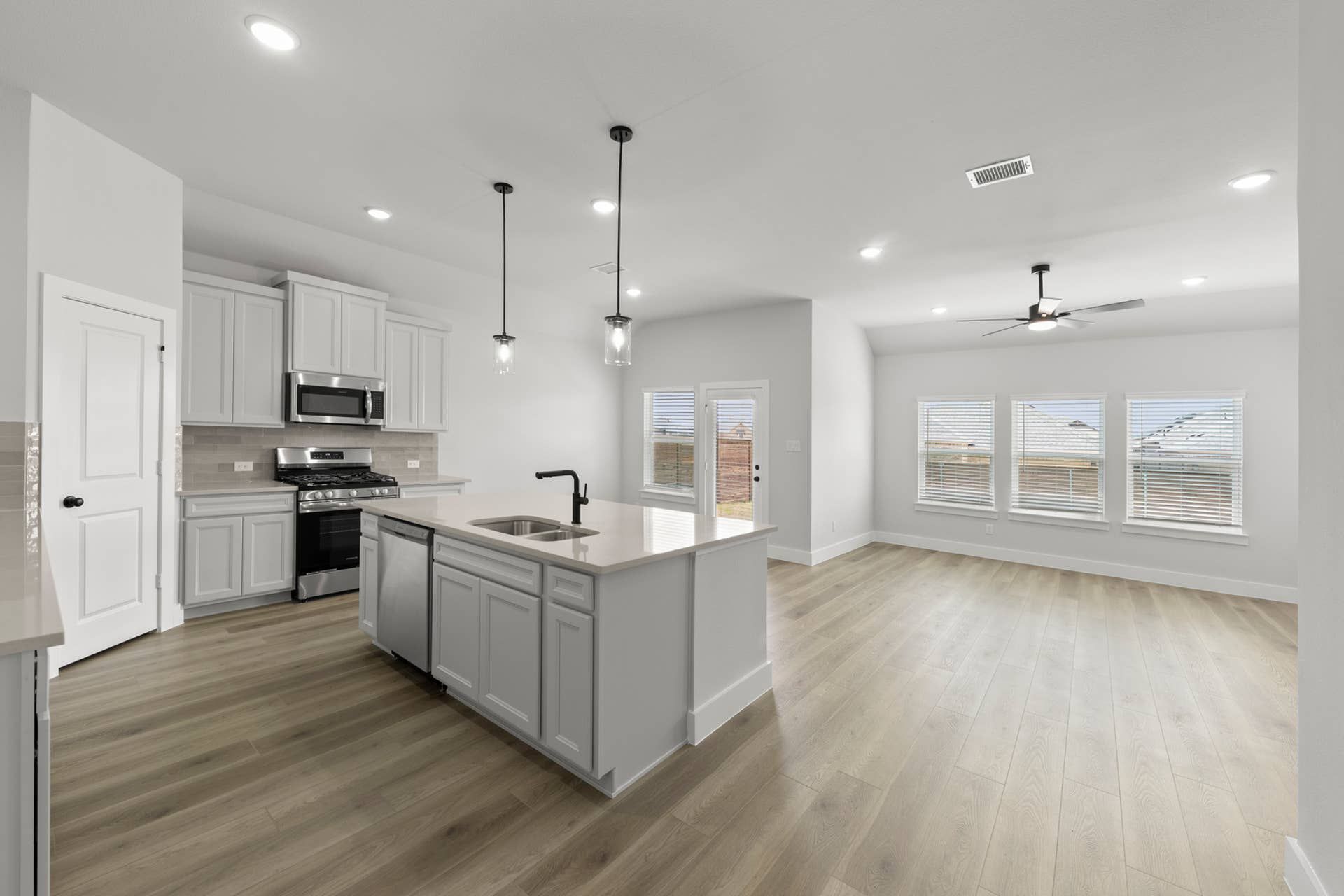 Modern kitchen with island, pendant lighting, and open floor plan.
