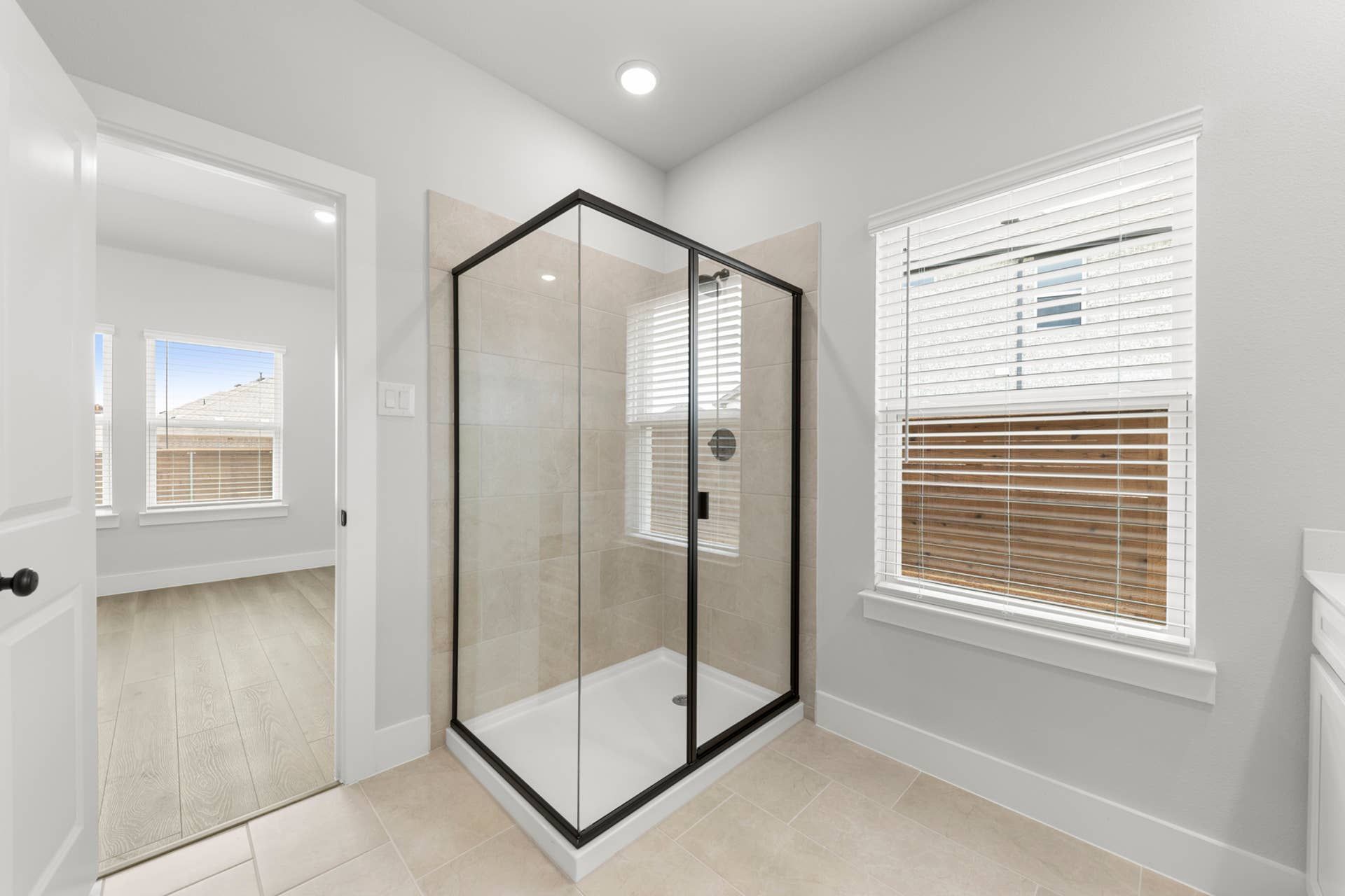 Modern bathroom with glass shower enclosure and natural light.