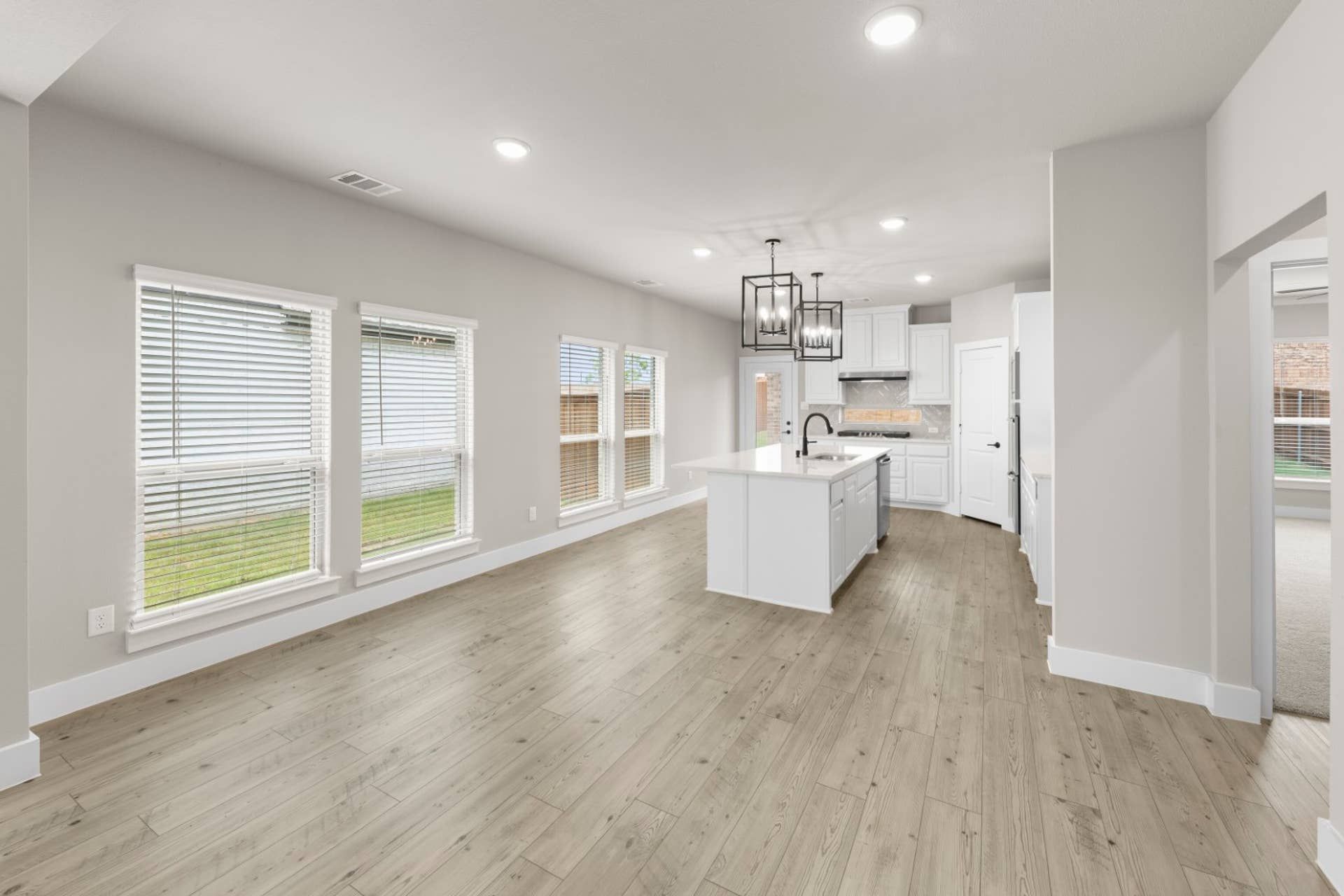 Spacious modern kitchen and dining area with large windows and hardwood floors.