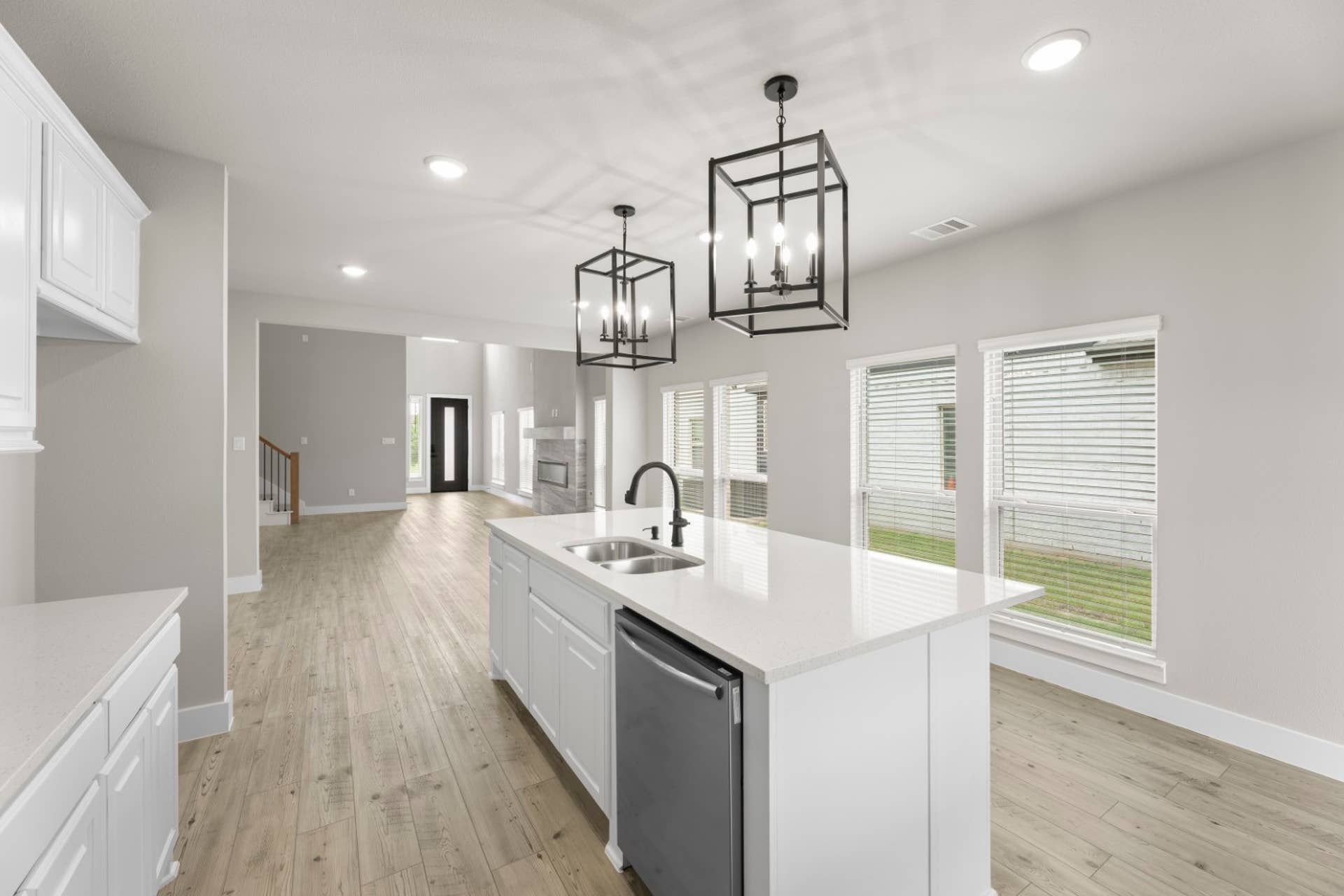 Modern kitchen with island, pendant lights, and hardwood floors.