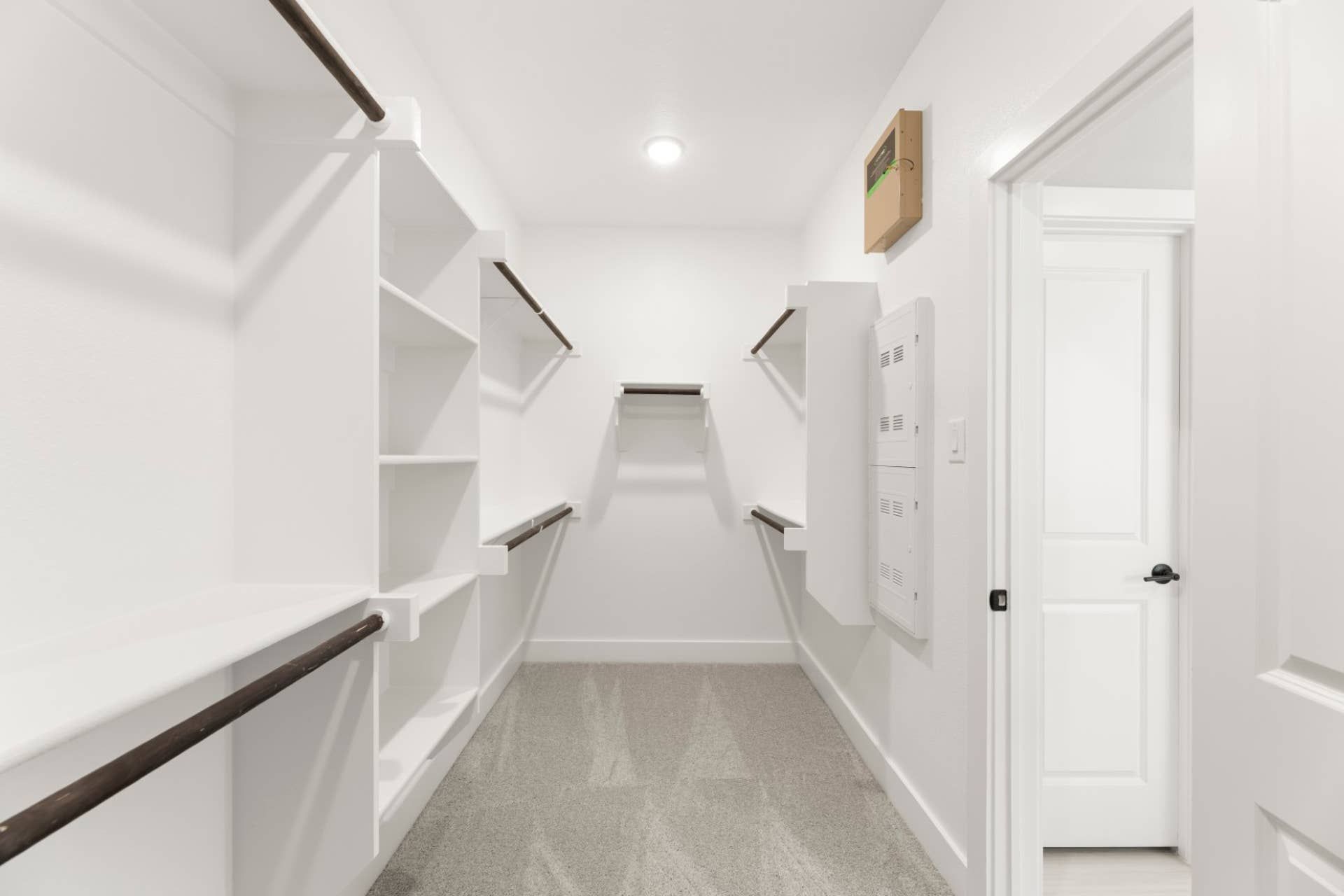 Spacious walk-in closet with built-in shelves and hanging rods.