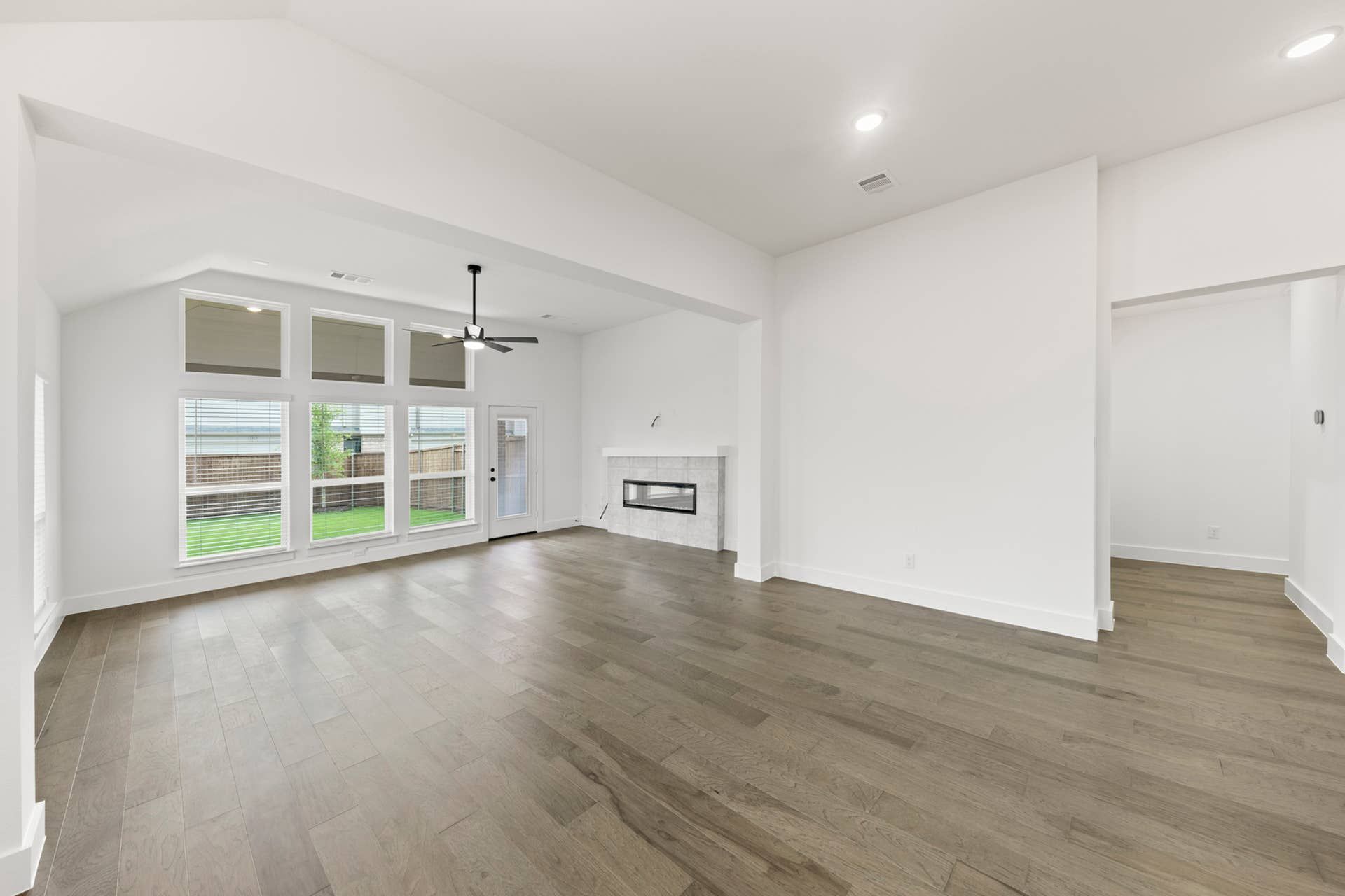 Spacious dining room with hardwood floors, large windows, and modern fireplace.