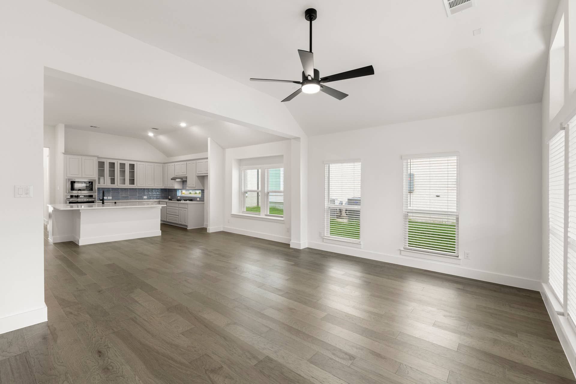 Spacious open-concept living area with modern kitchen and large windows.