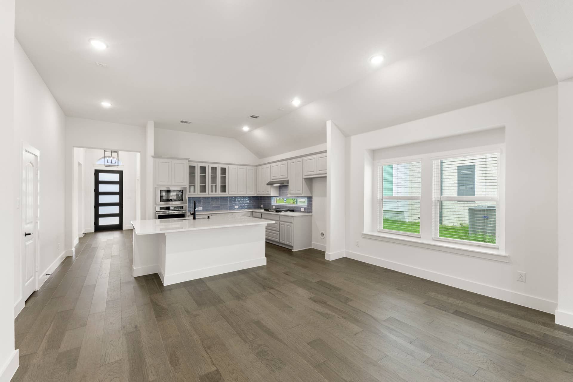 Spacious modern kitchen and dining area with sleek cabinetry and hardwood floors.
