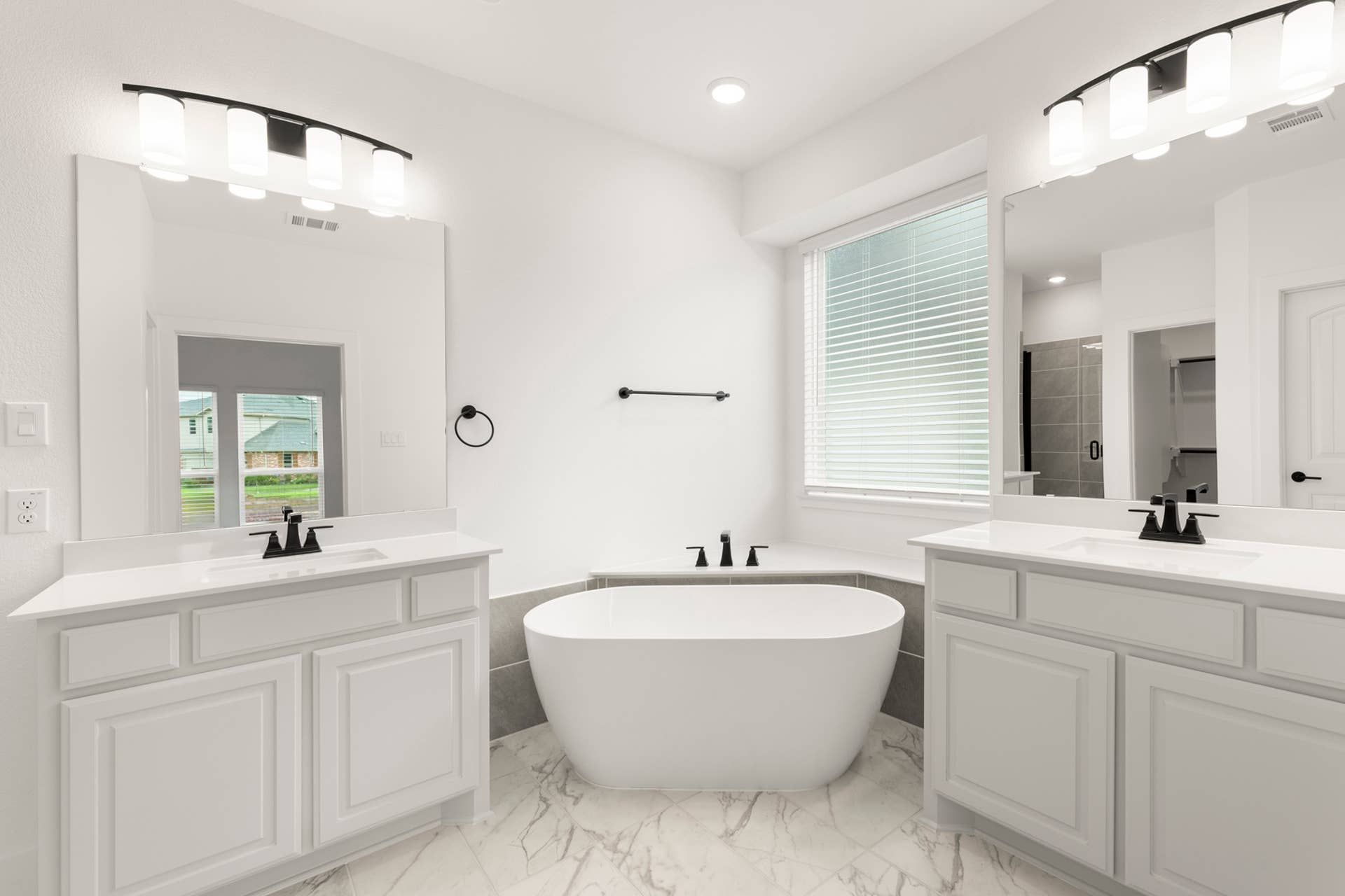 Modern bathroom with freestanding bathtub and dual vanities.