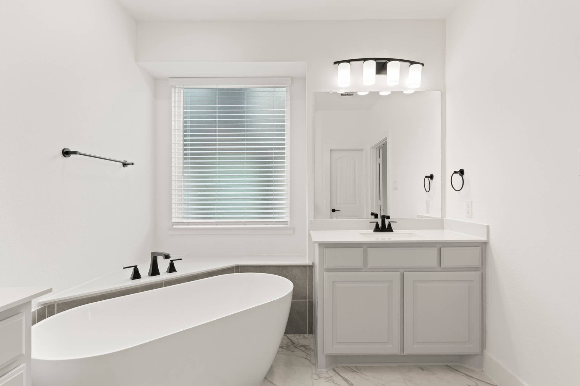Modern bathroom with freestanding tub, sleek fixtures, and bright natural lighting.