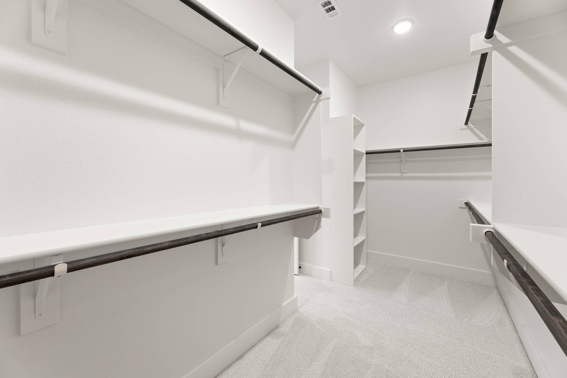 Spacious walk-in closet with multiple shelves and hanging rods.