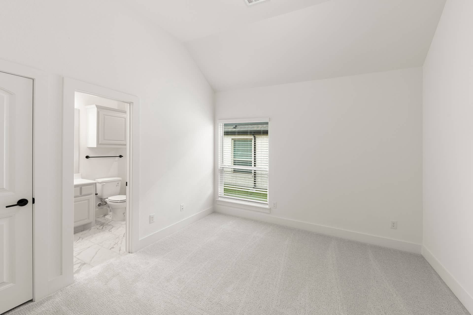Spacious bedroom with carpet flooring and en-suite bathroom.