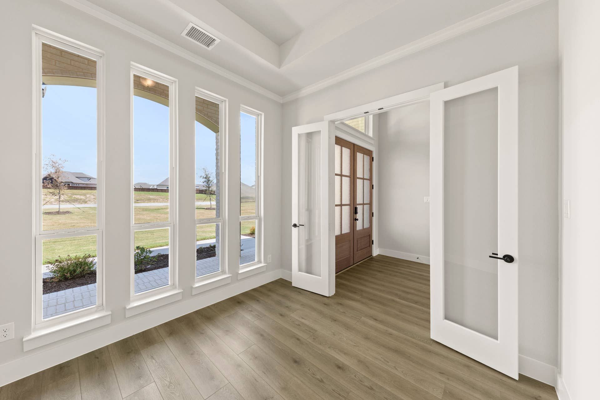 Bright study with hardwood floors and large windows overlooking the garden.