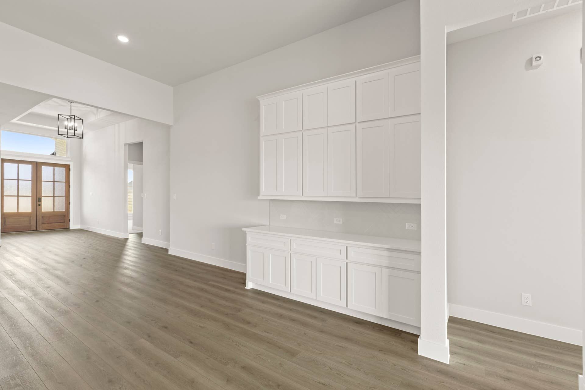 Spacious interior nook with hardwood floors and white built-in cabinetry.