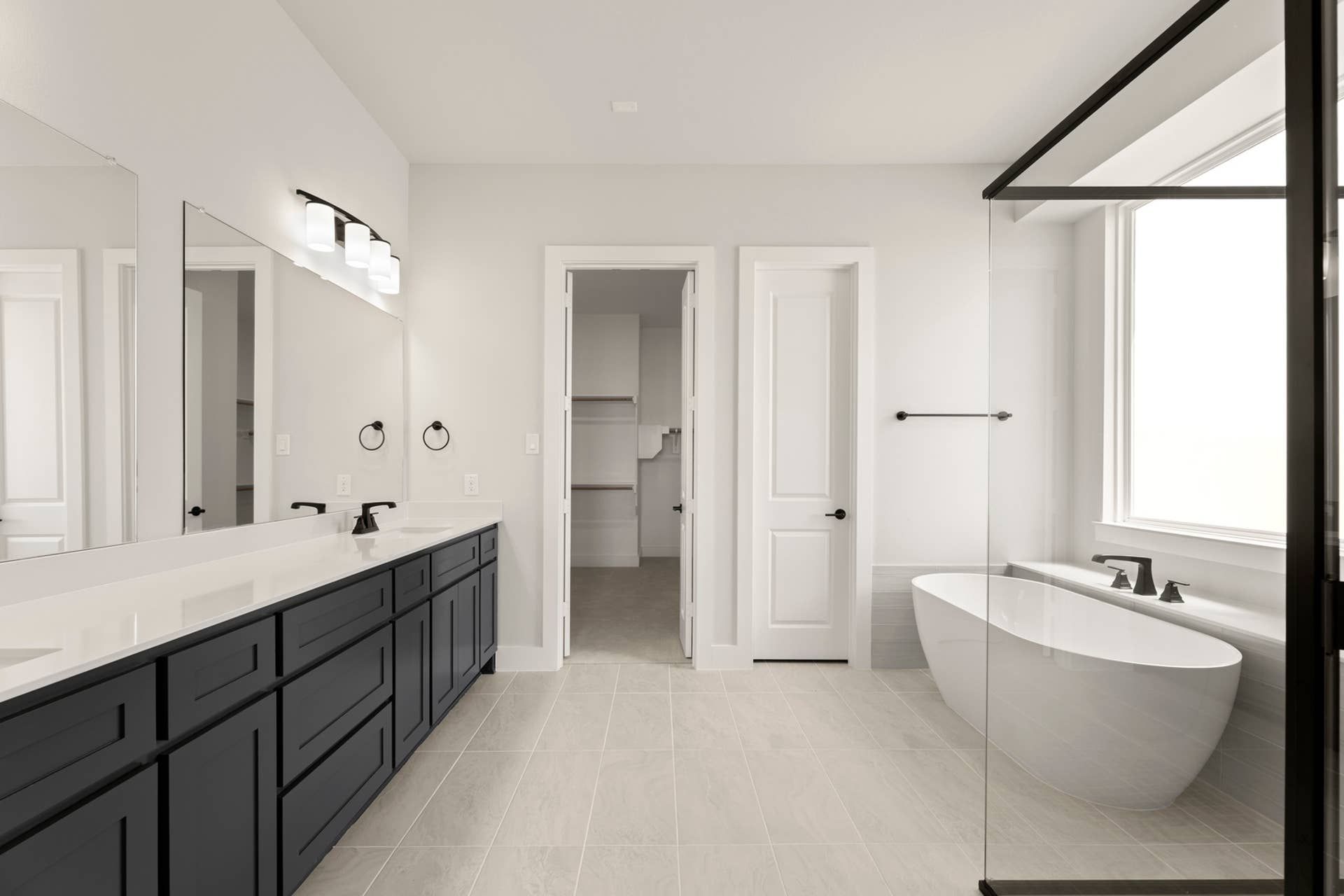 Elegant bathroom with freestanding tub, large vanity, and modern fixtures.
