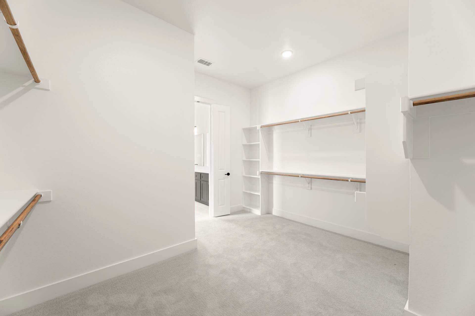 Spacious walk-in closet with built-in shelves and hanging rods.